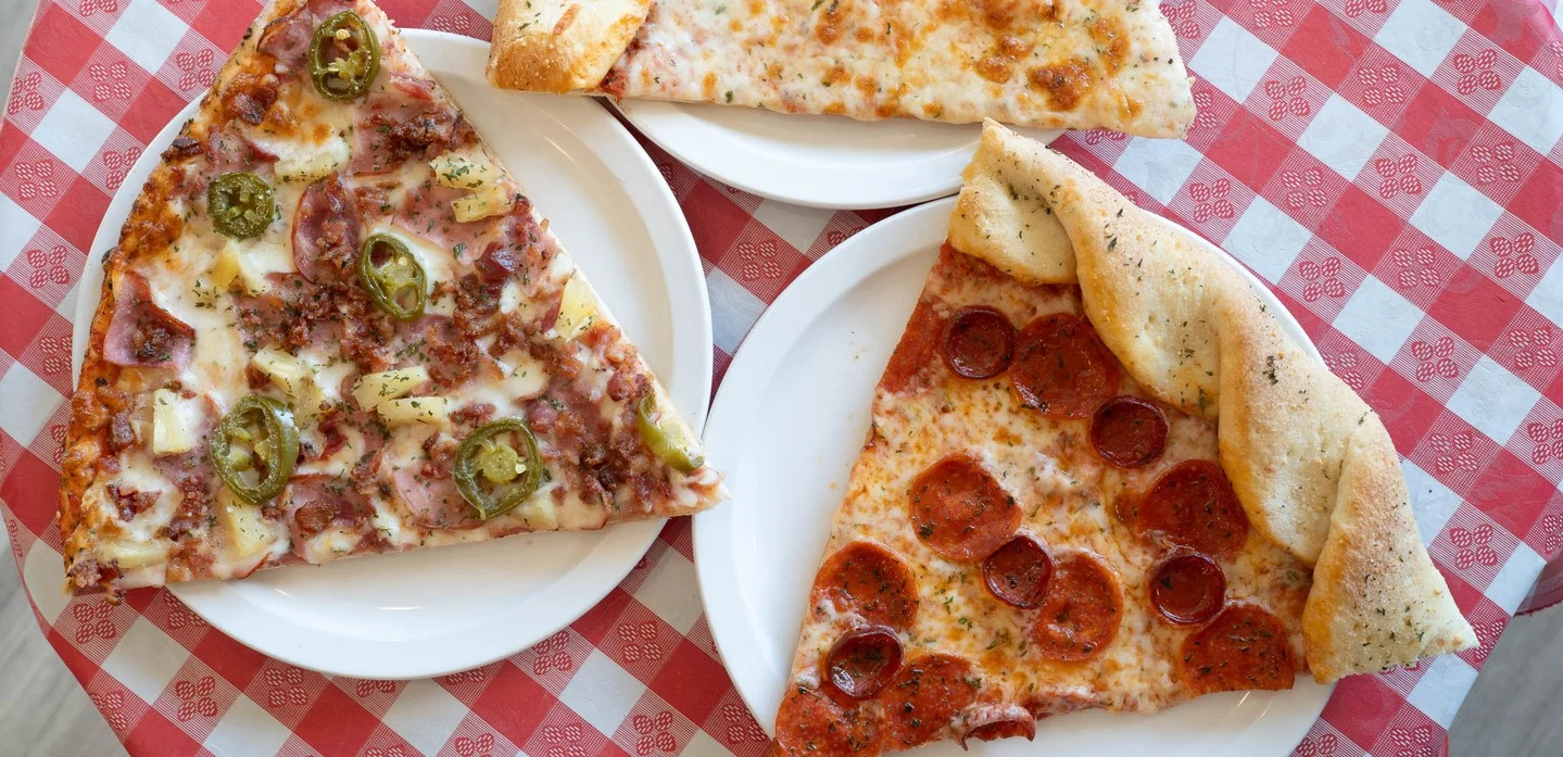 Three slices of classic pizza on a checkered tablecloth