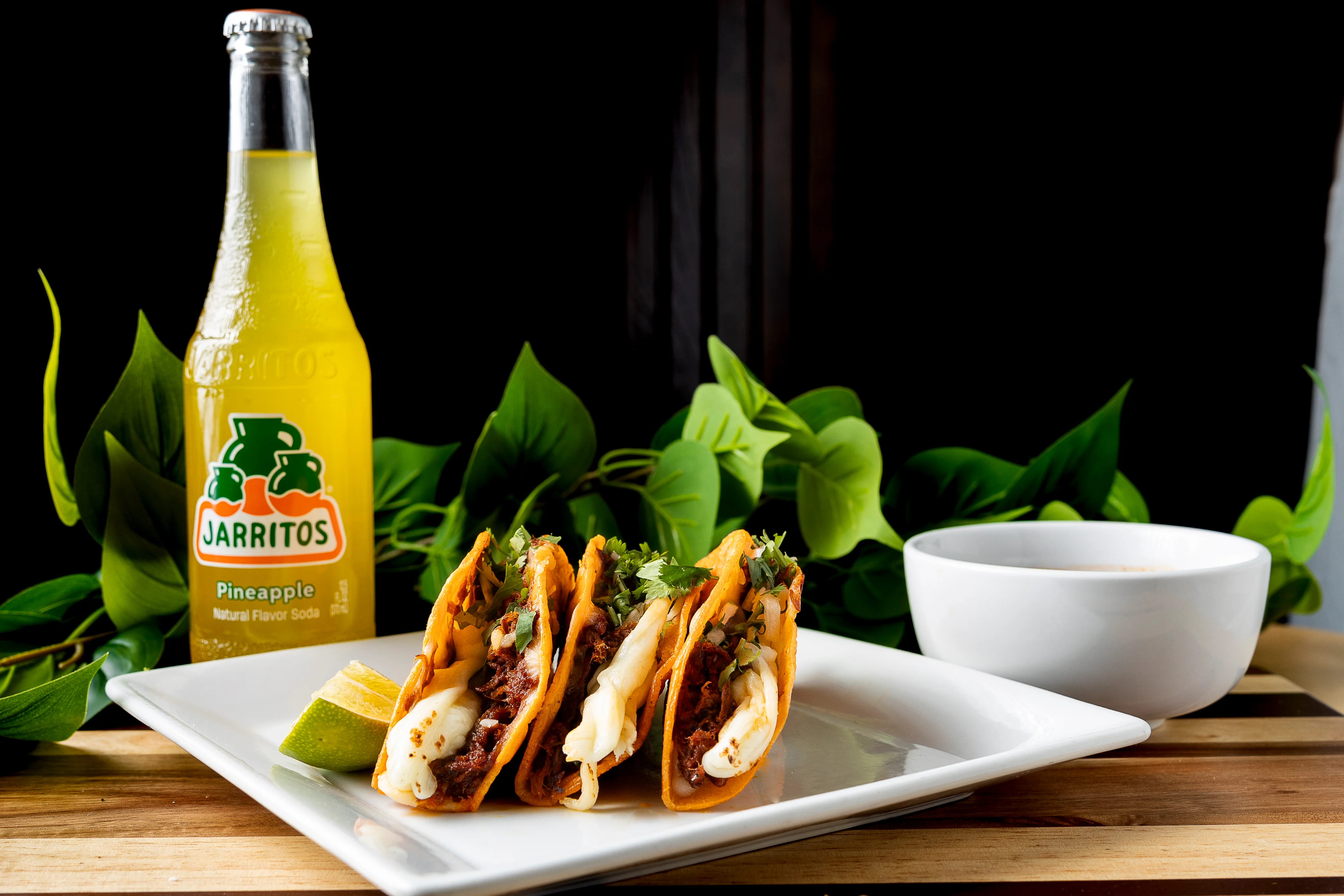 Three crispy tacos with beef and cheese, served with pineapple soda