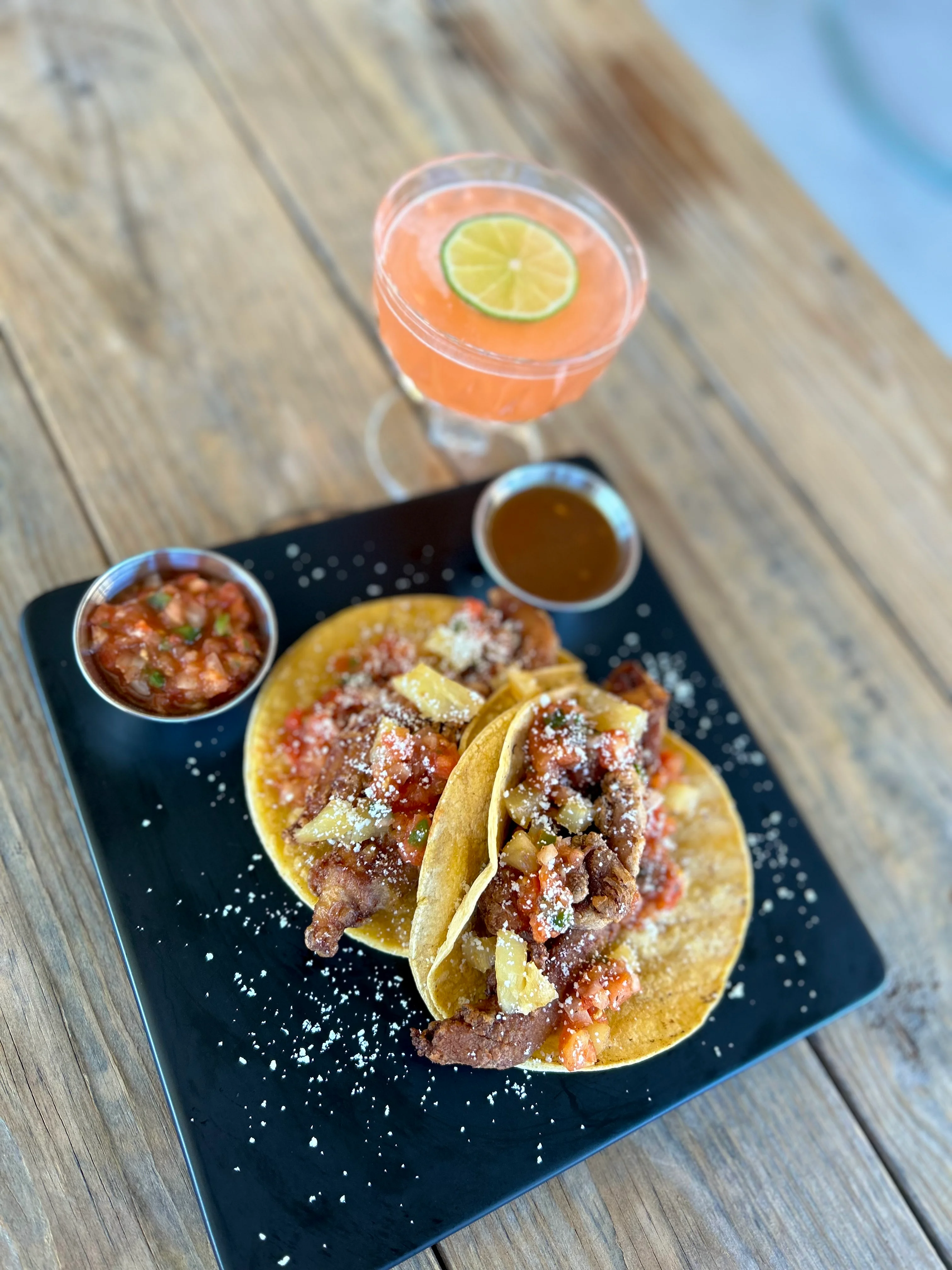 Delicious Mexican tacos al pastor with a refreshing cocktail