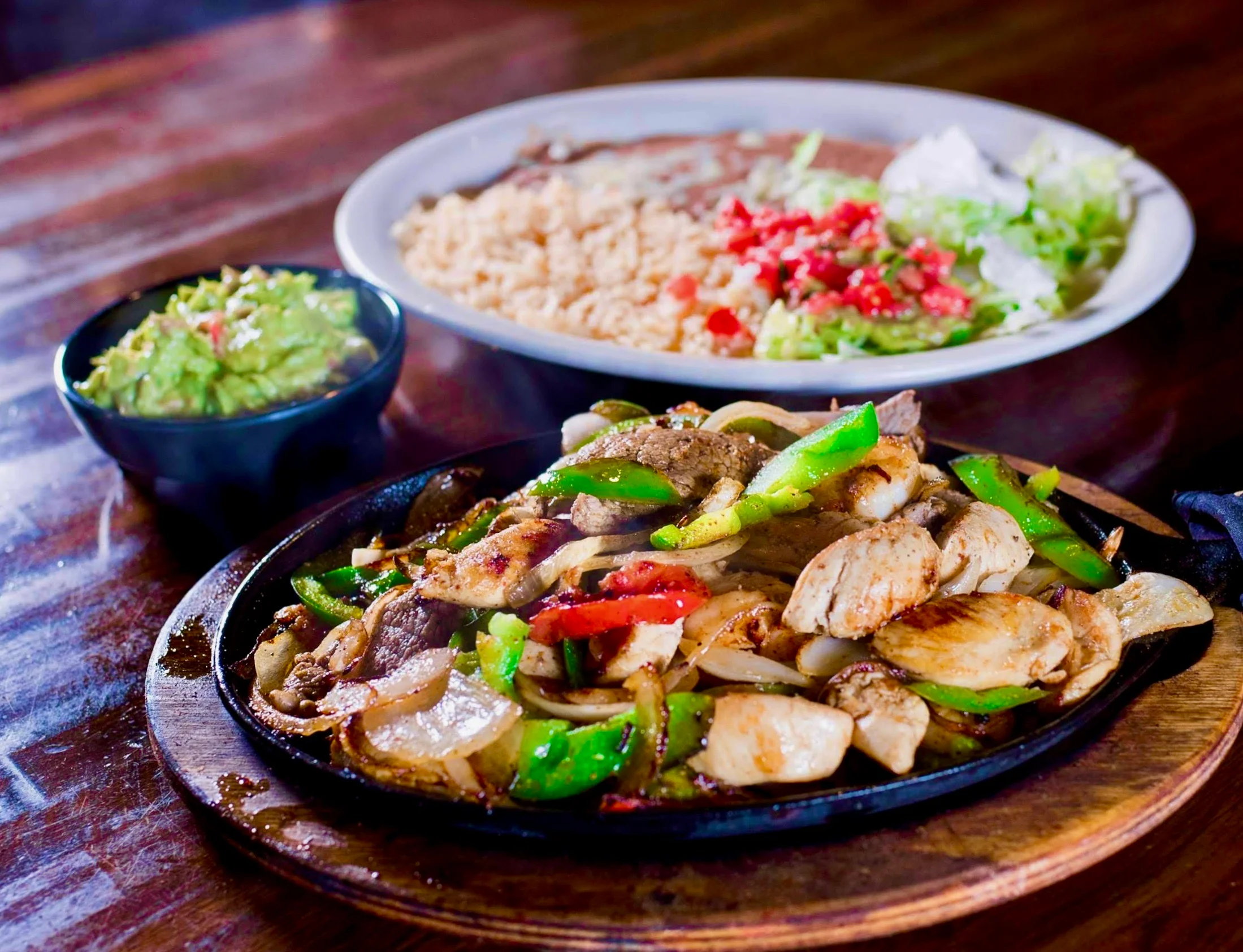 Sizzling fajitas served with guacamole and rice