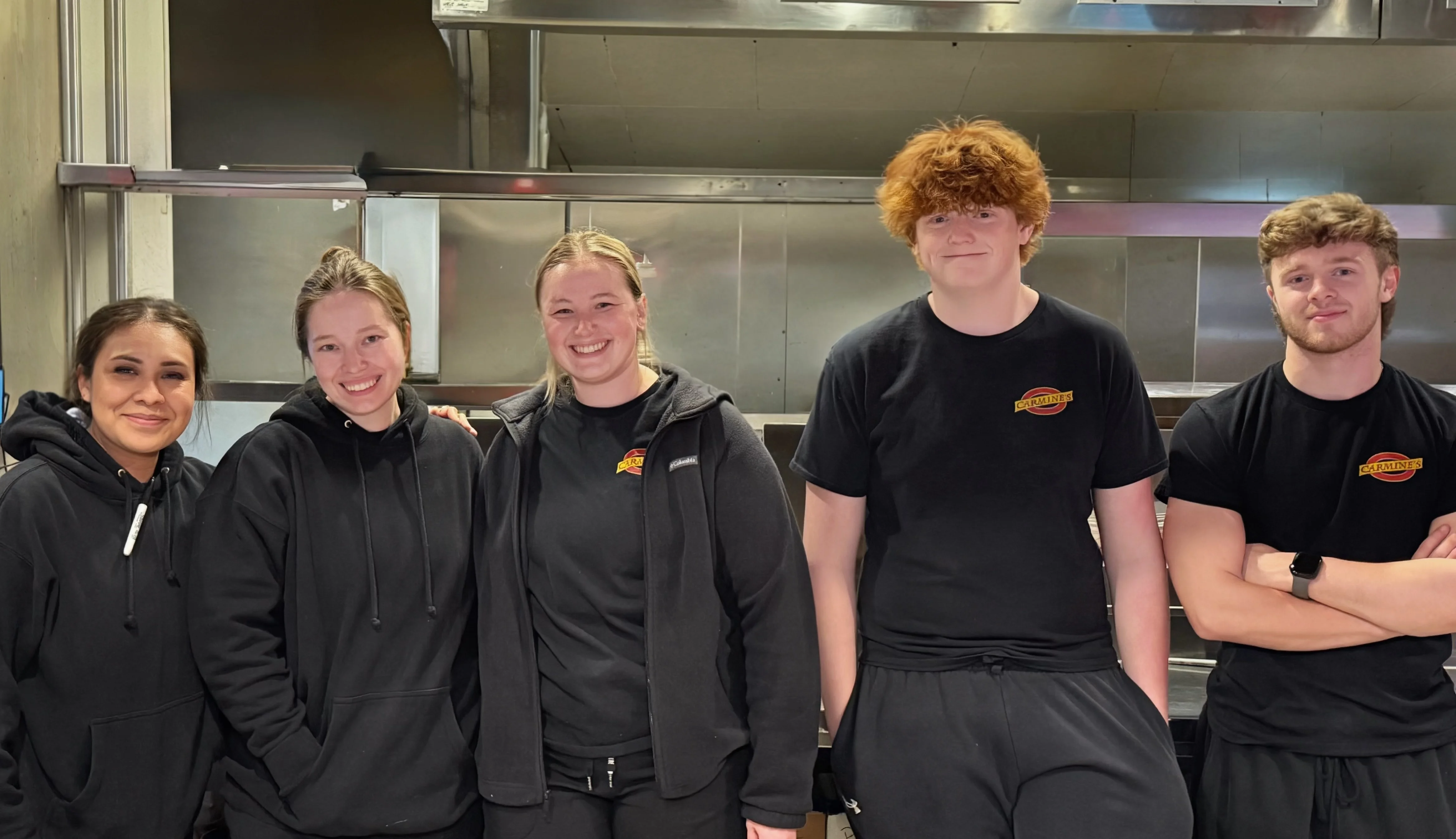 Restaurant staff posing together in a kitchen