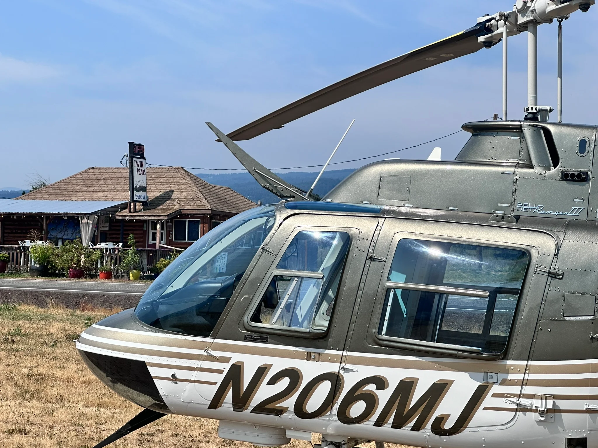 Helicopter parked near Twin Peaks restaurant in a scenic landscape