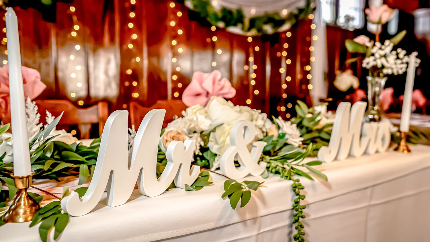 Elegant wedding table decor with Mr & Mrs sign and floral arrangements