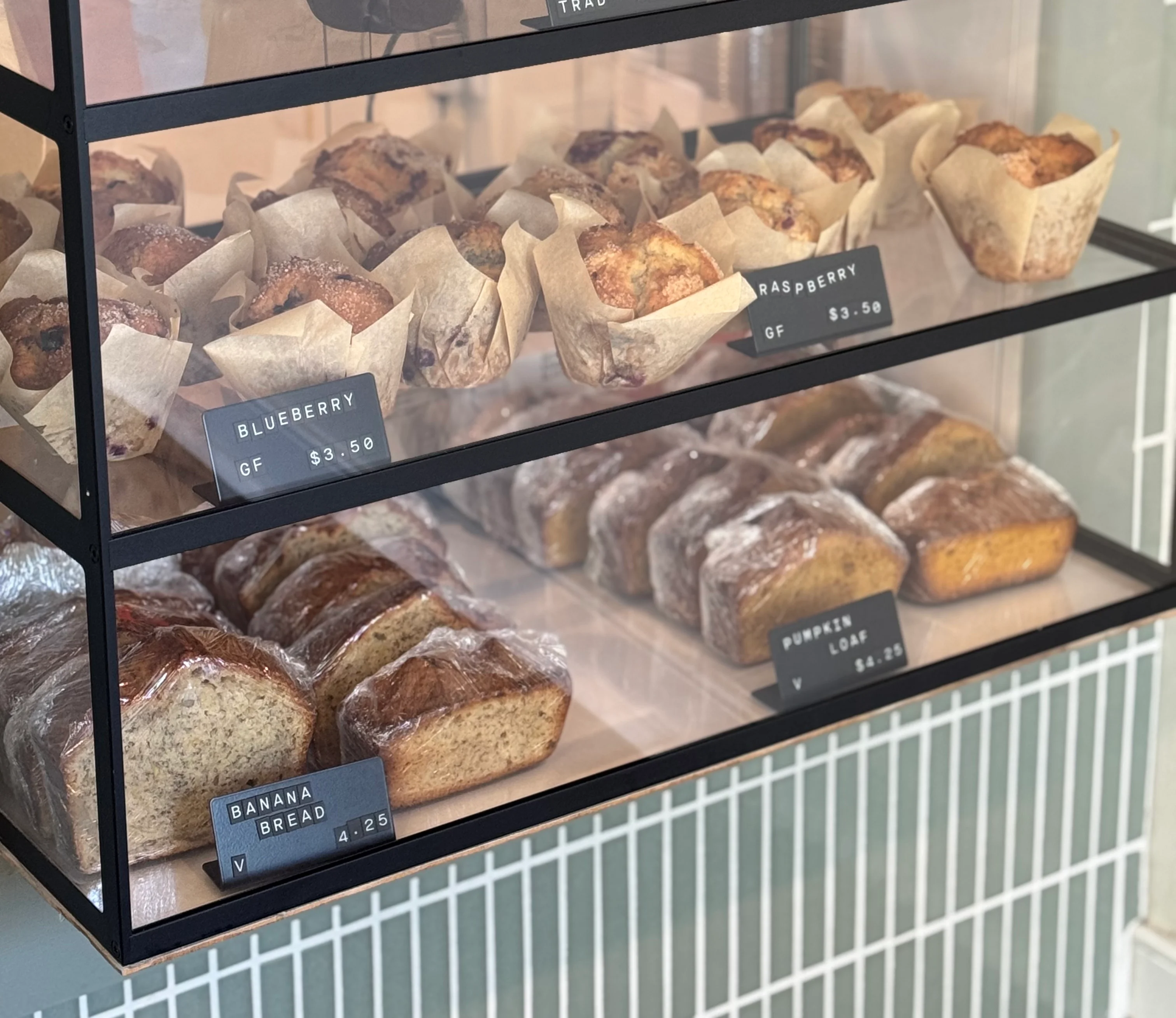 Assorted muffins including blueberry and banana bread in a bakery display