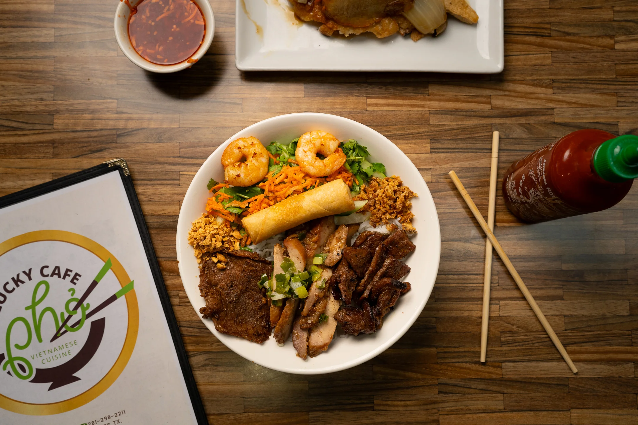 Vietnamese rice bowl with grilled meats and shrimp