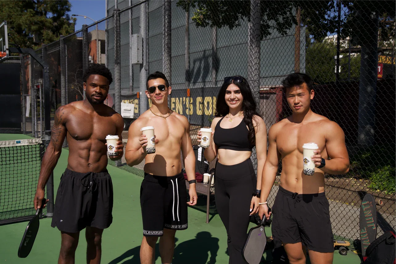 Group of friends enjoying drinks at a sports court