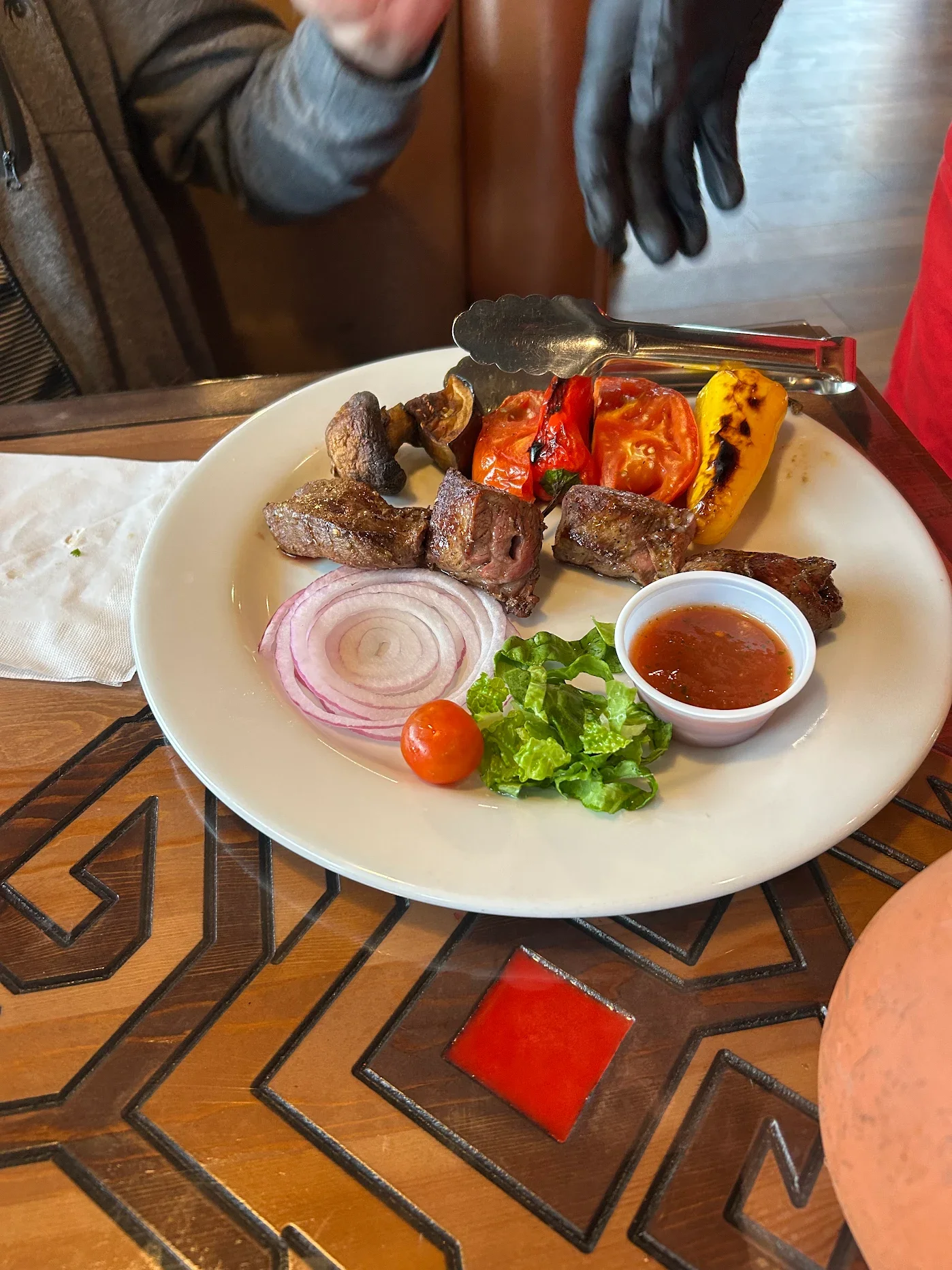 Grilled kebabs served with vegetables and sauce