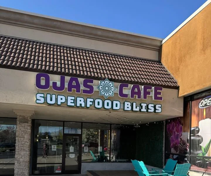 Exterior of Ojas Café in West Jordan, Utah, showing entrance signage and building facade