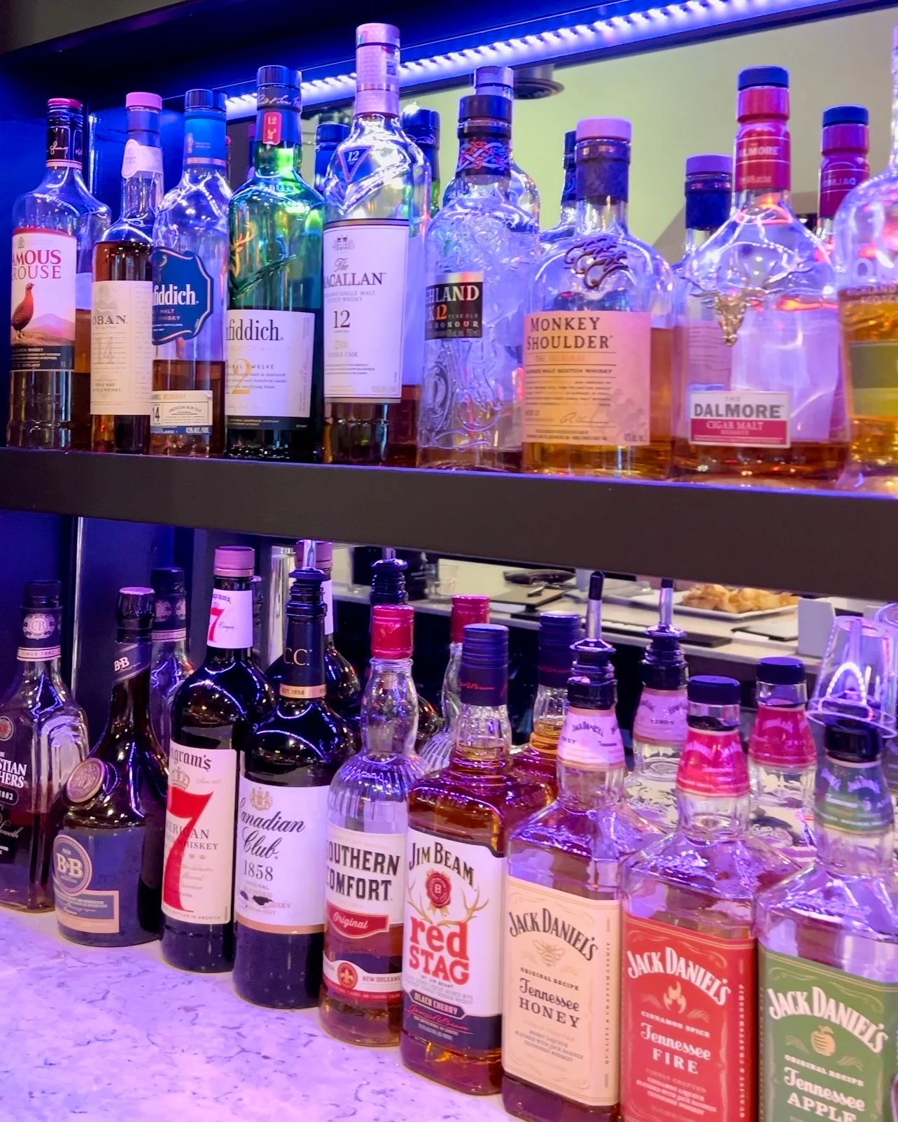 Well-stocked bar with various whiskey bottles on display