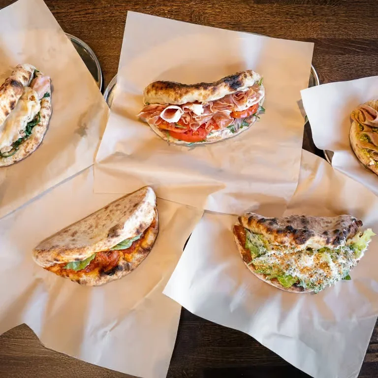 Assorted Italian panini sandwiches on parchment paper