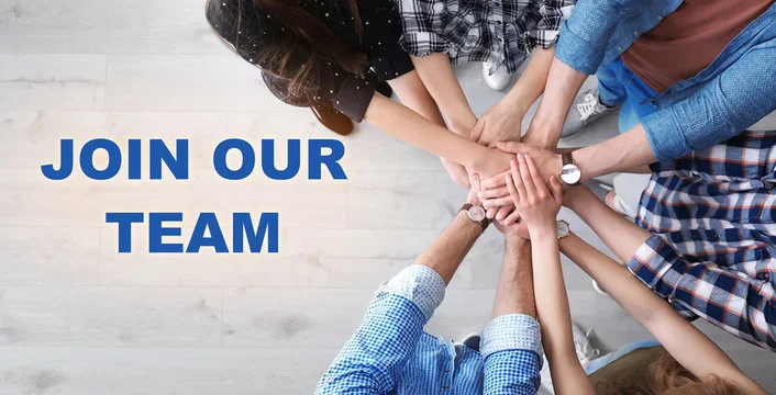 Team members joining hands in unity for recruitment