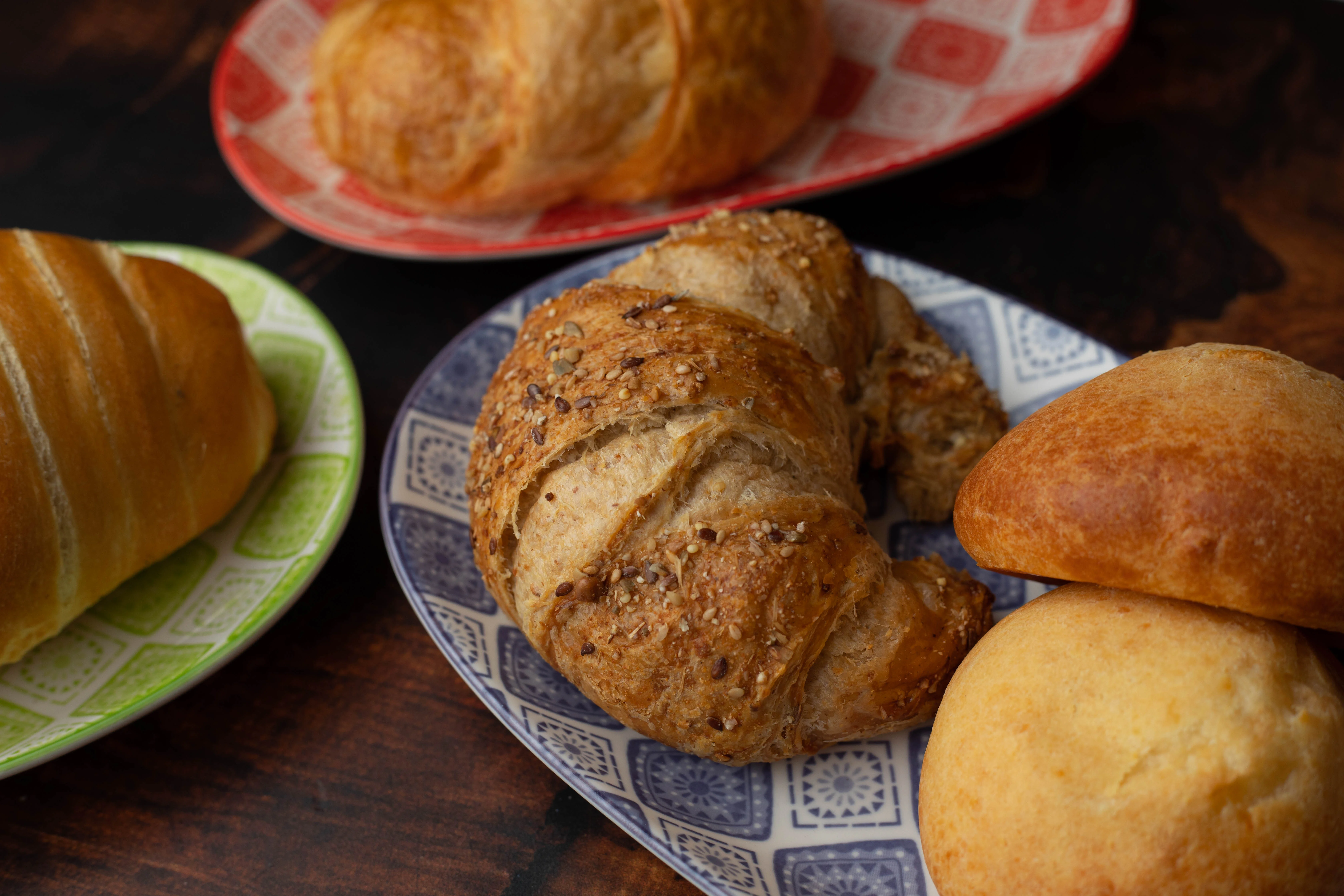 Freshly baked croissants and rolls on decorative plates