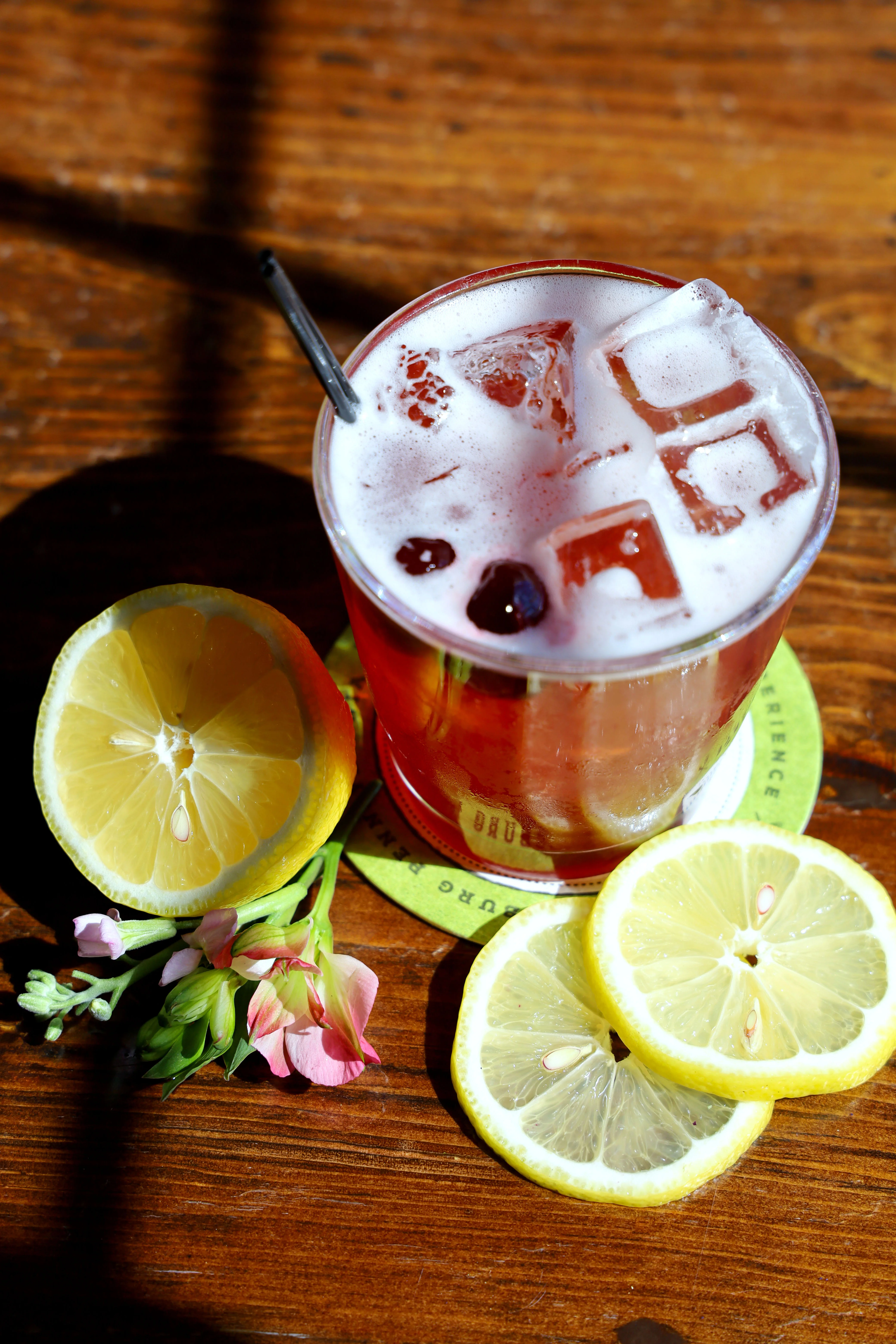A vibrant Cherry Blossom Sour cocktail garnished with cherry blossoms.