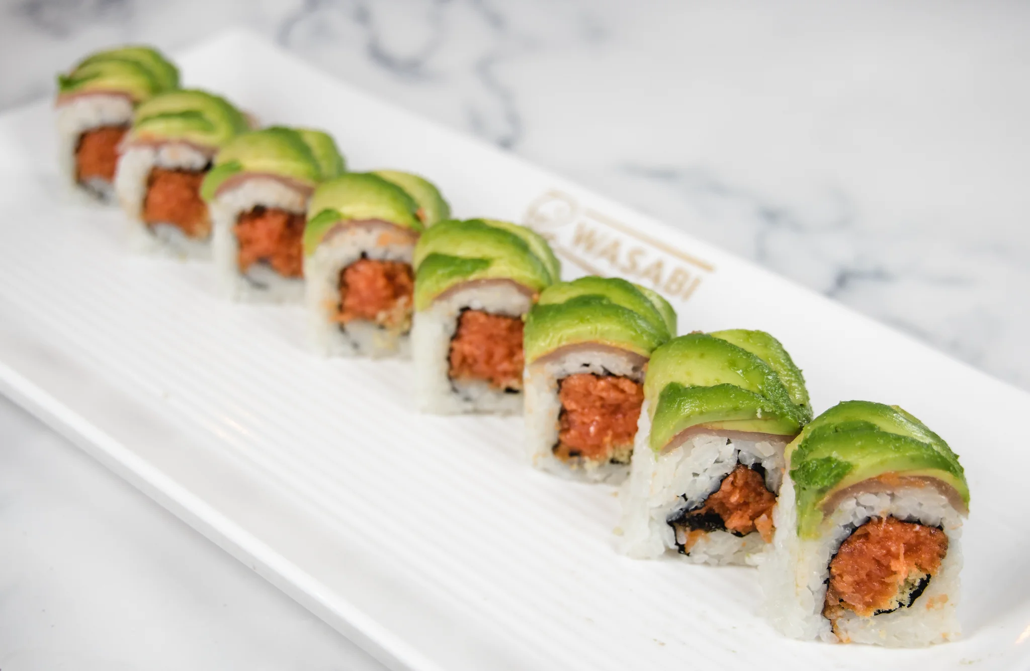 Japanese sushi roll topped with avocado