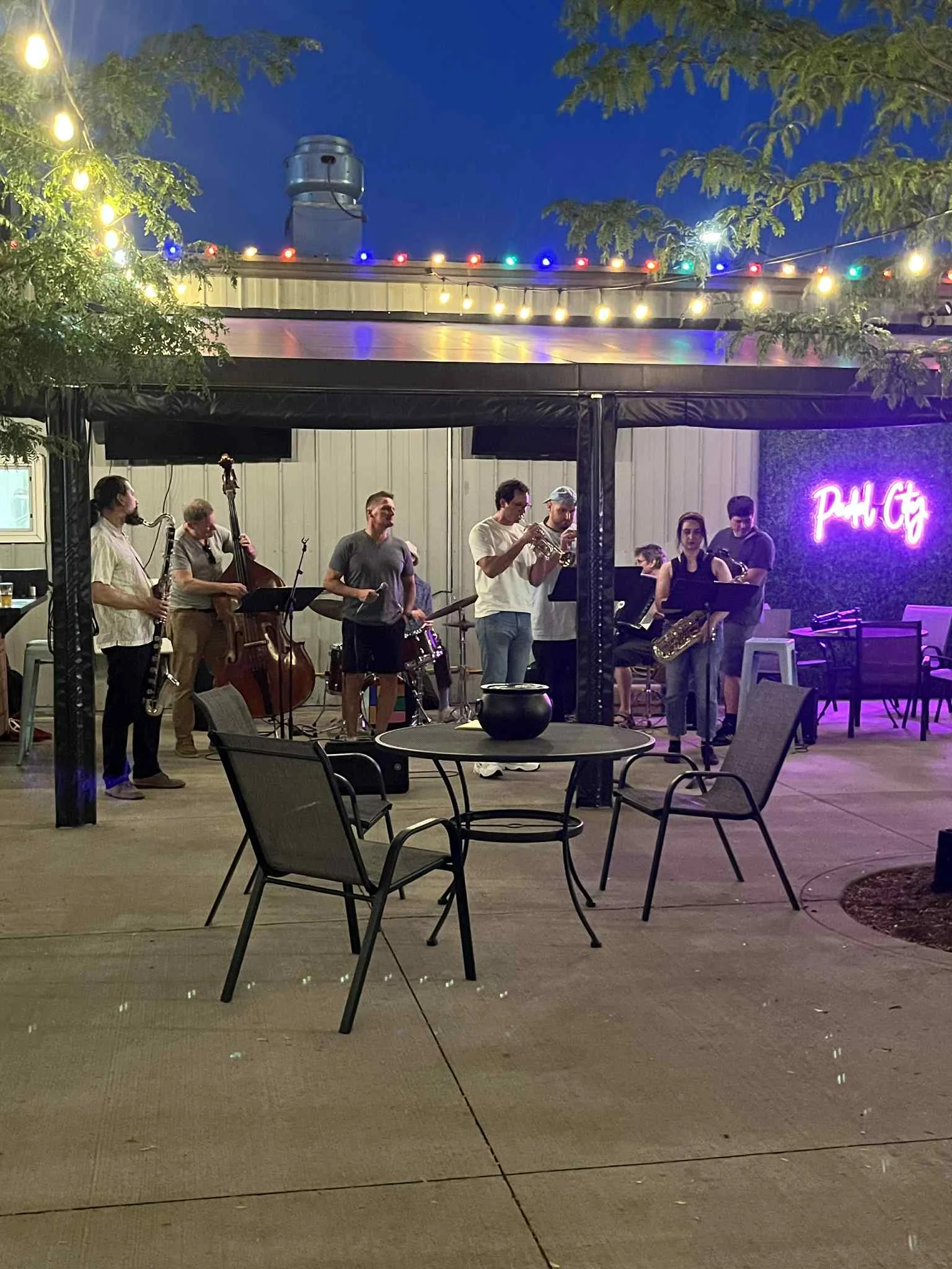 Live jazz band performing outdoors under string lights