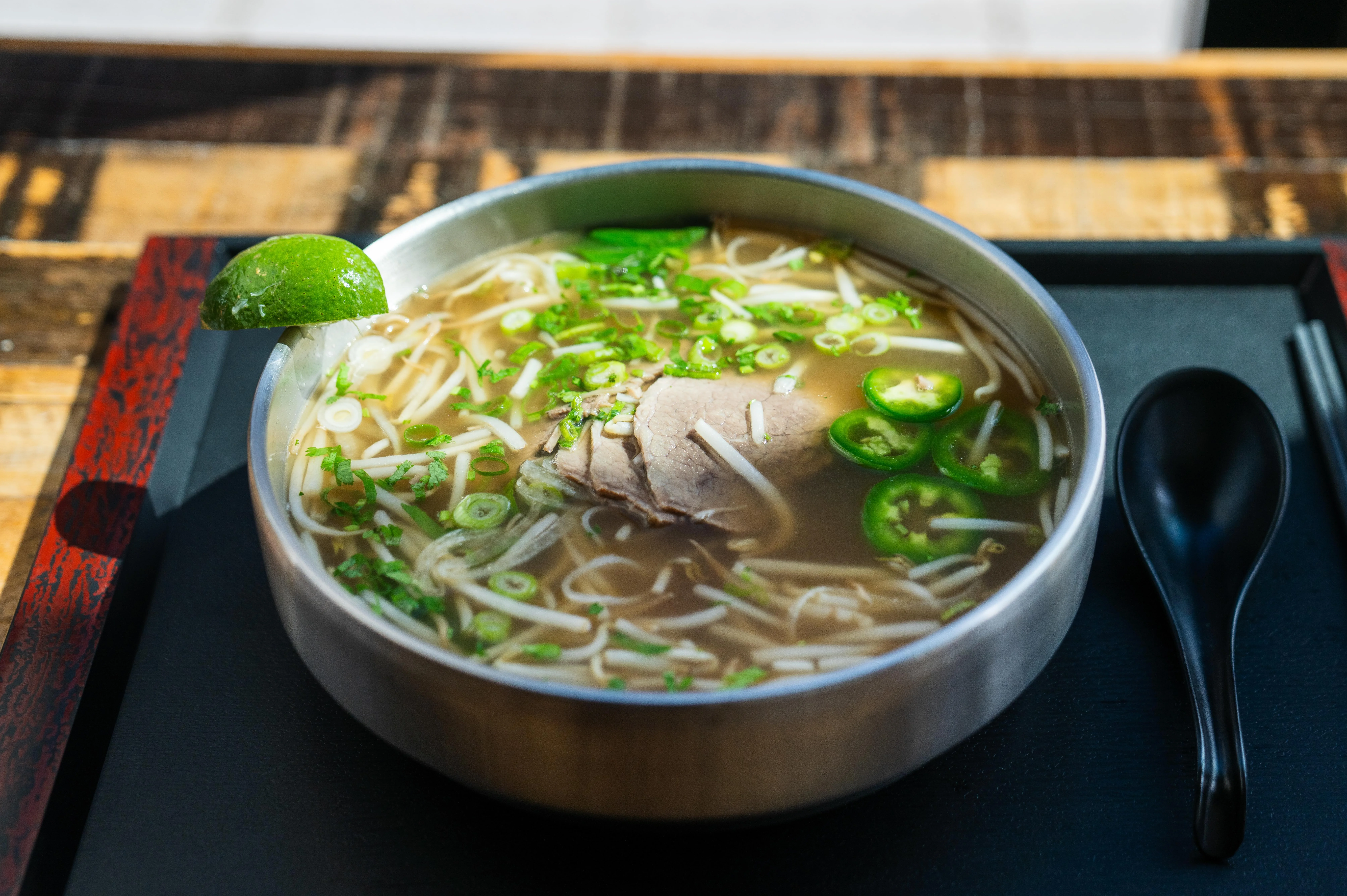 Bowl of Vietnamese pho with beef and fresh herbs