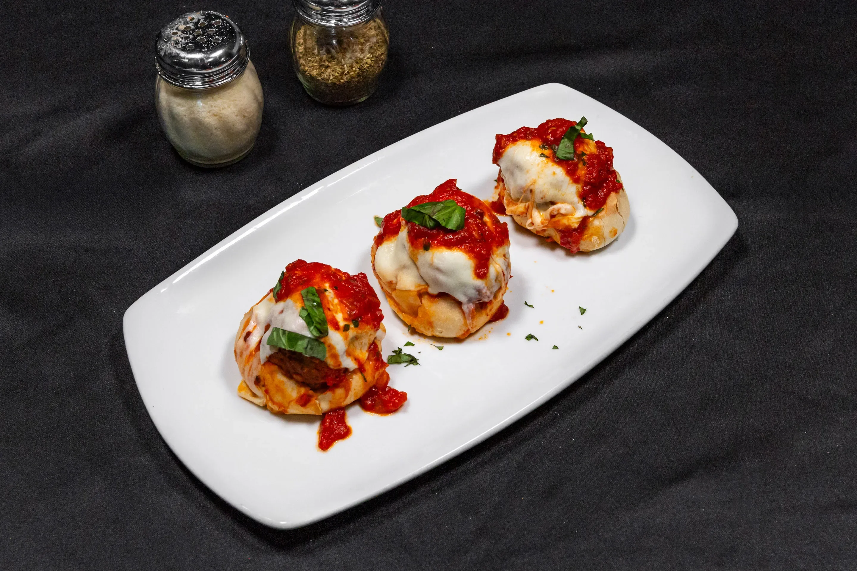 Italian meatball sliders topped with marinara and mozzarella