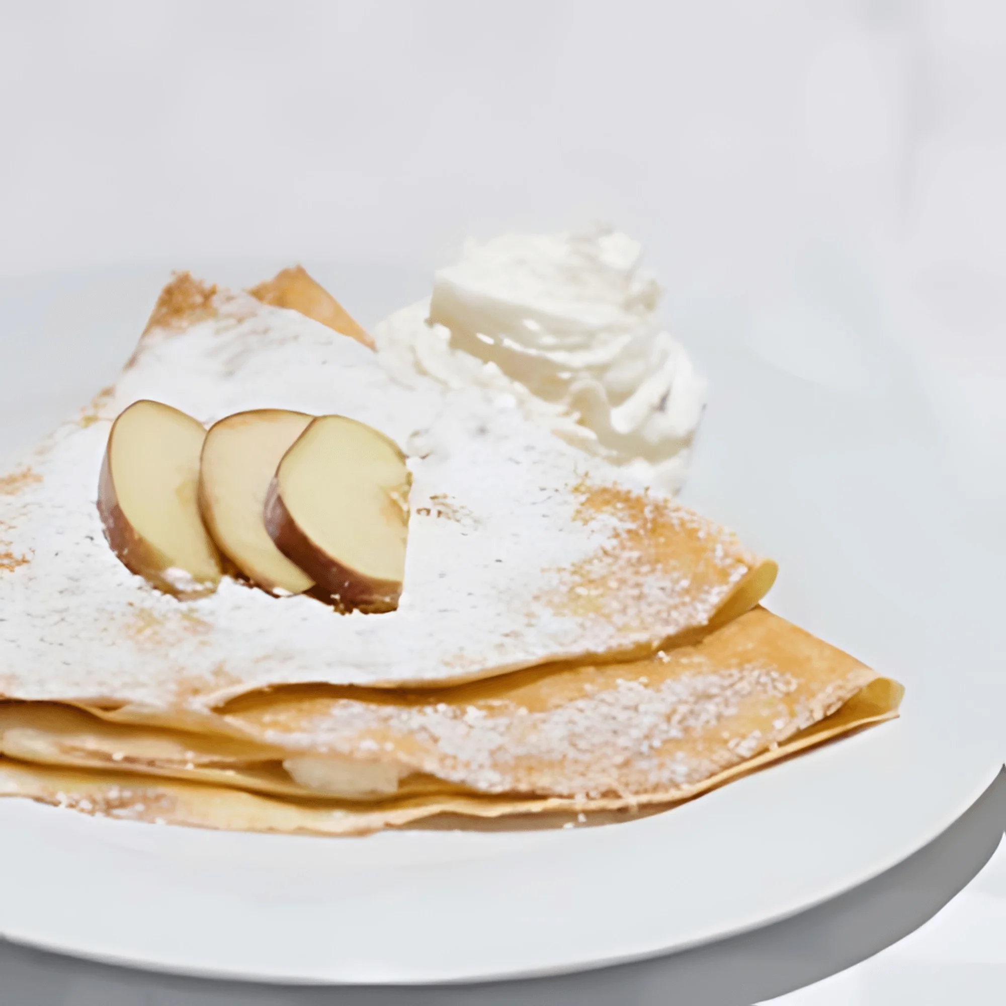 Delicious French crêpes with apple slices and whipped cream