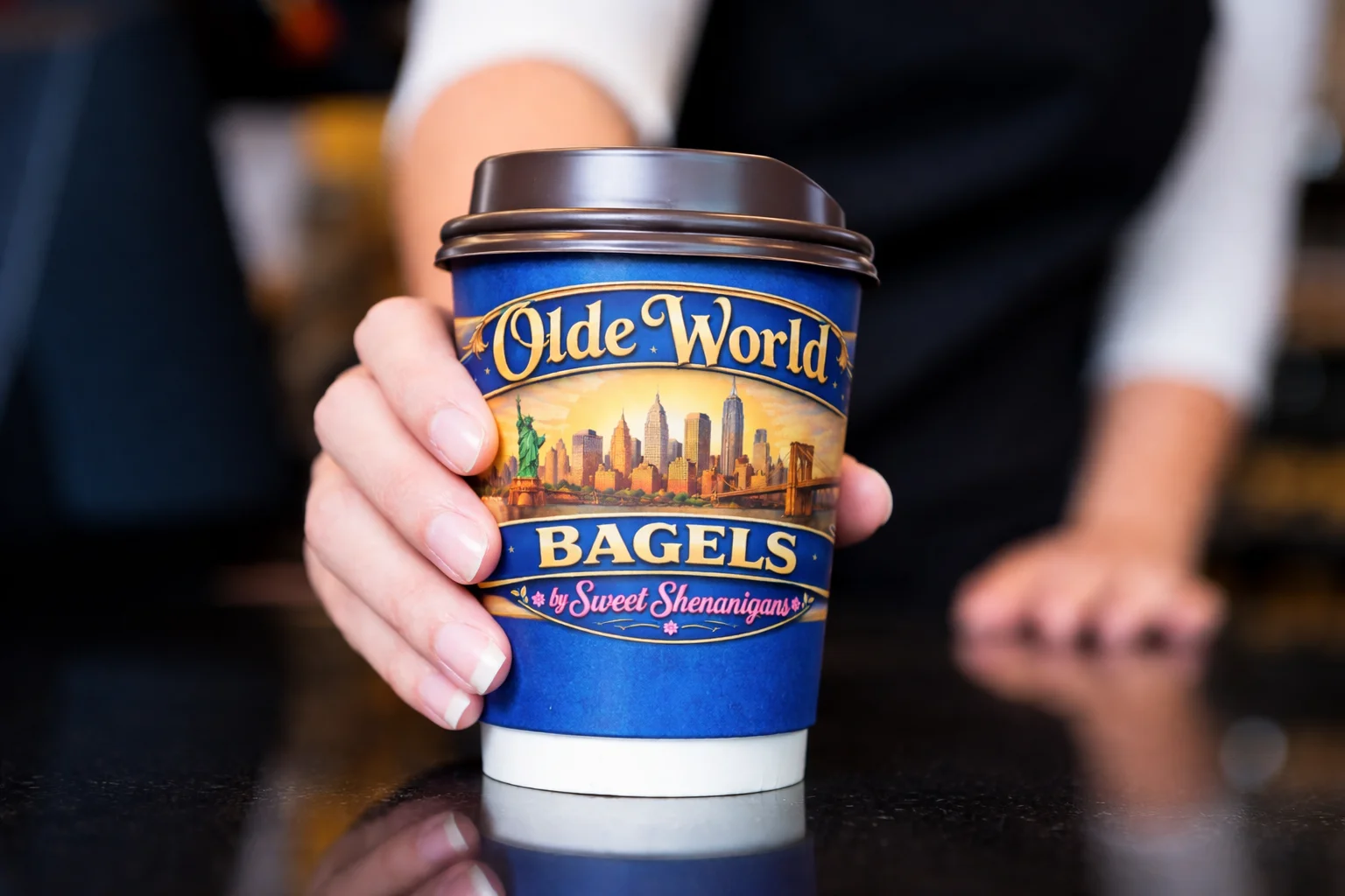 A coffee cup with a logo, showcasing a warm beverage.