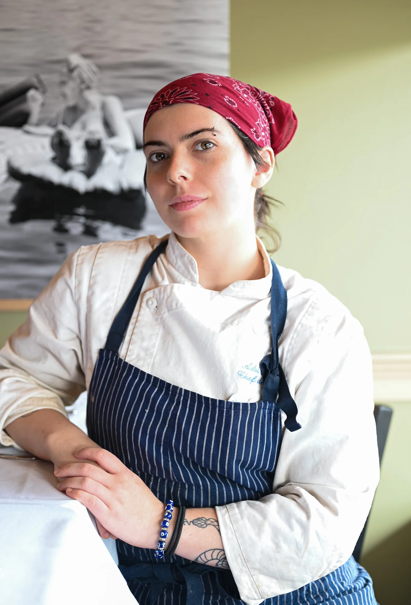 Chef in a striped apron posing in a restaurant setting