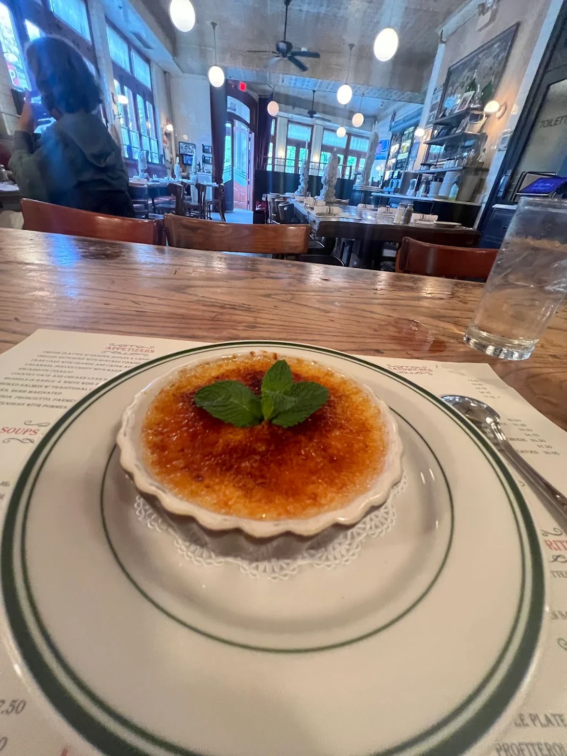 Classic French crème brûlée with caramelized sugar and mint garnish