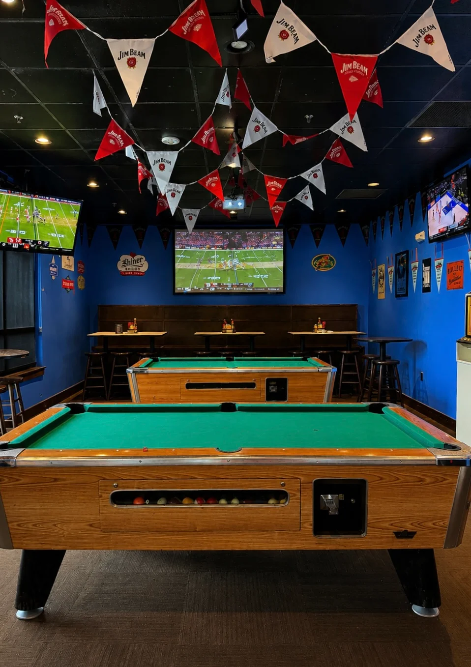 Lively sports bar with fans enjoying a game and playing pool
