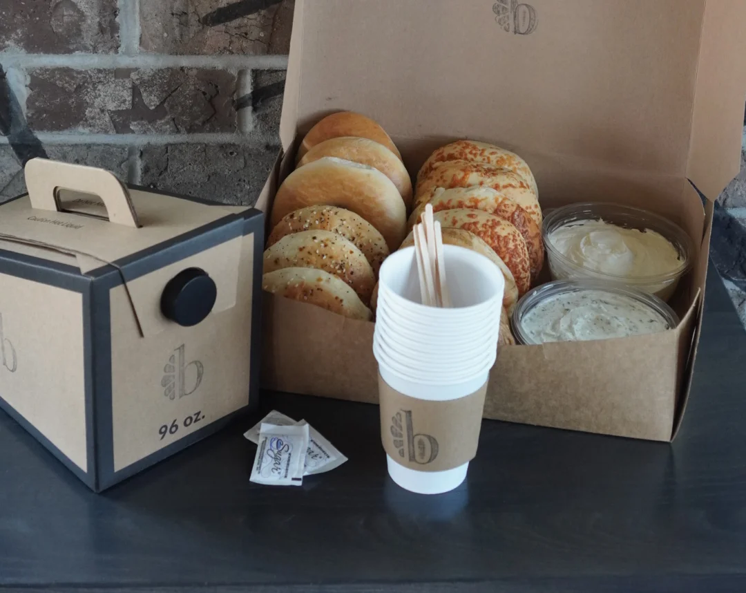 Box of bagels with a to go container of coffee for catering