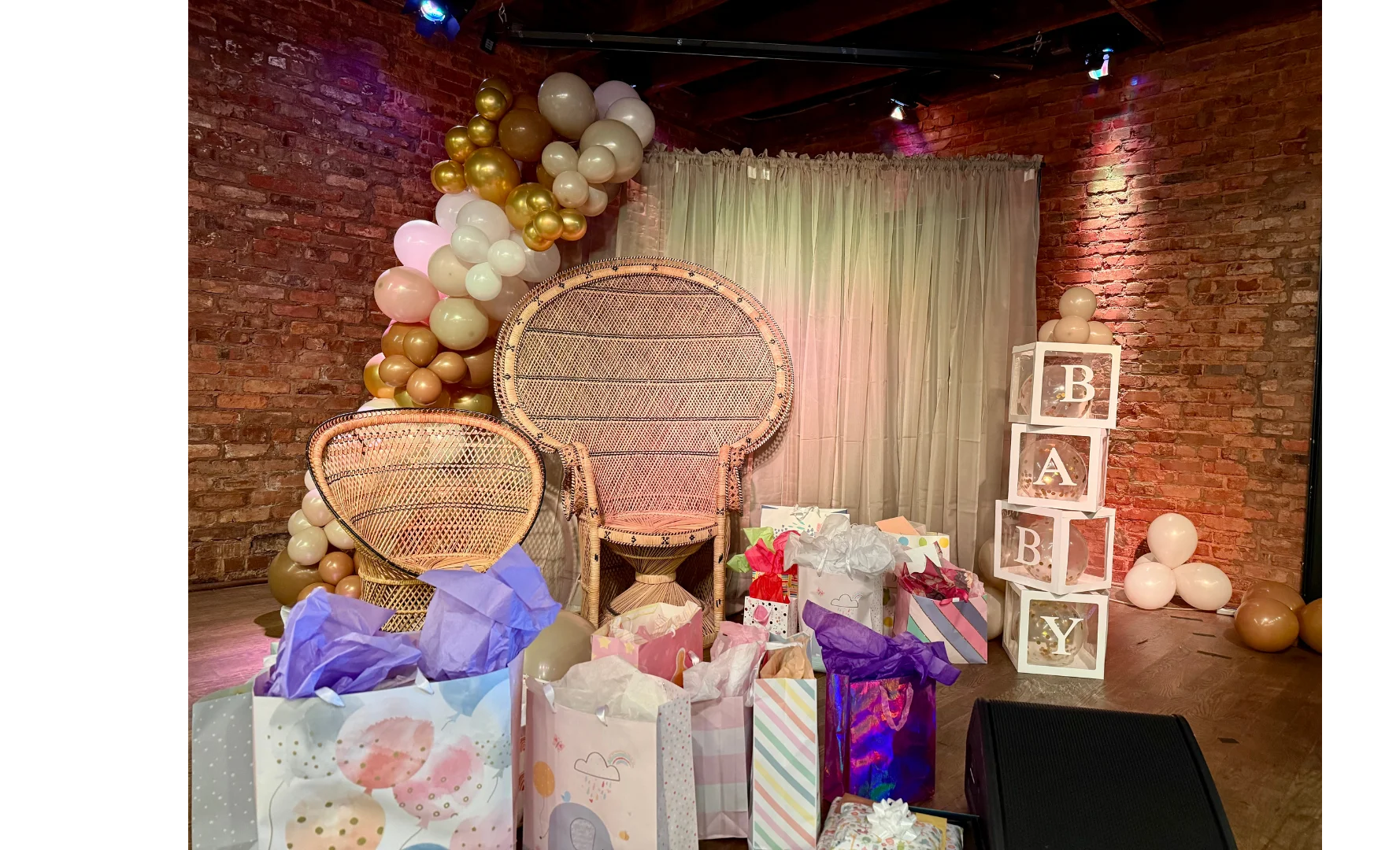 Decorative baby shower setup with gifts and balloon arch