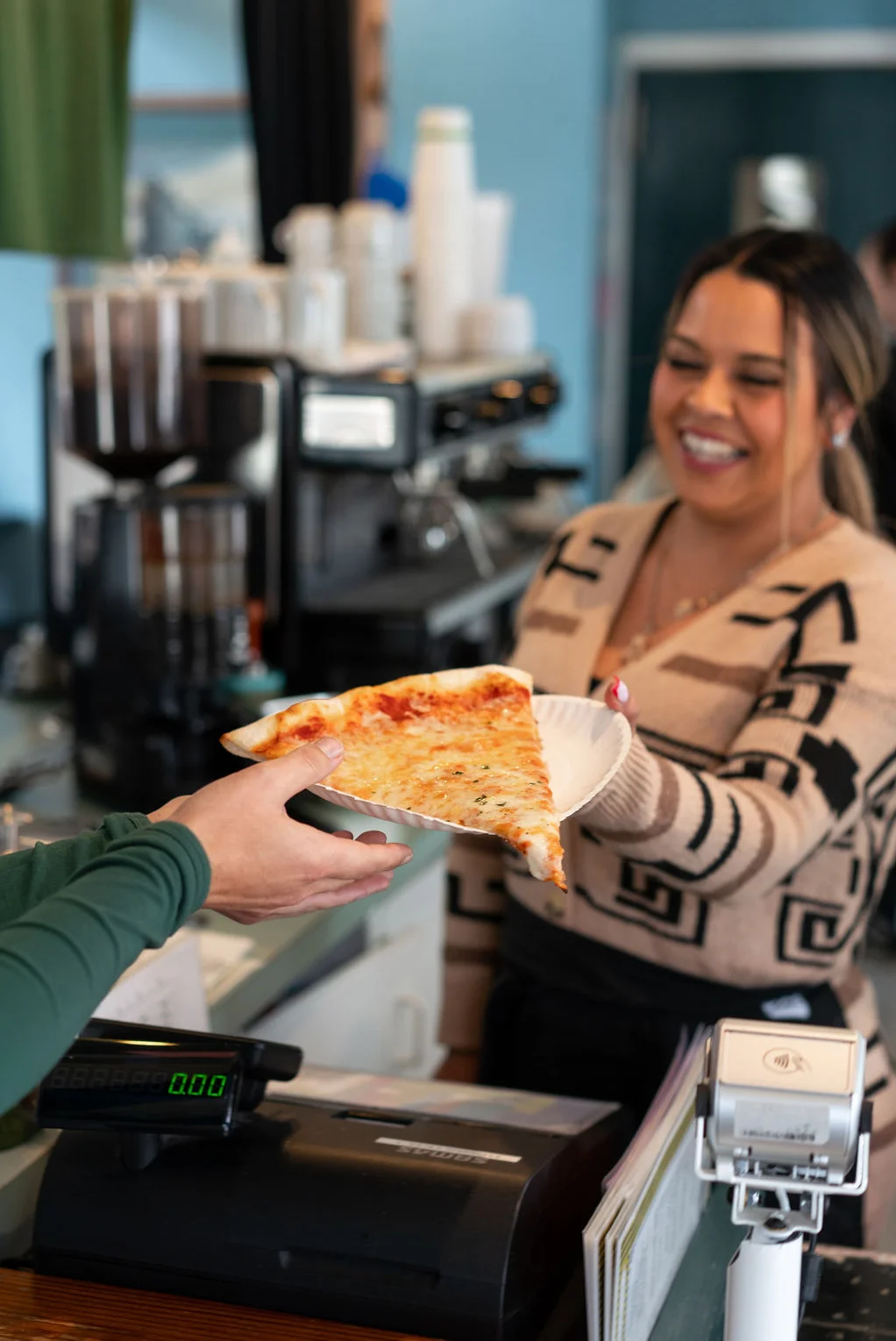 Woman handing customer pizza slice at Frankie's Pizza Mendocino California