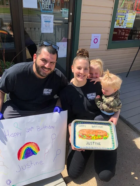 Celebrating a birthday with a colorful cake and cheerful decorations outside a deli
