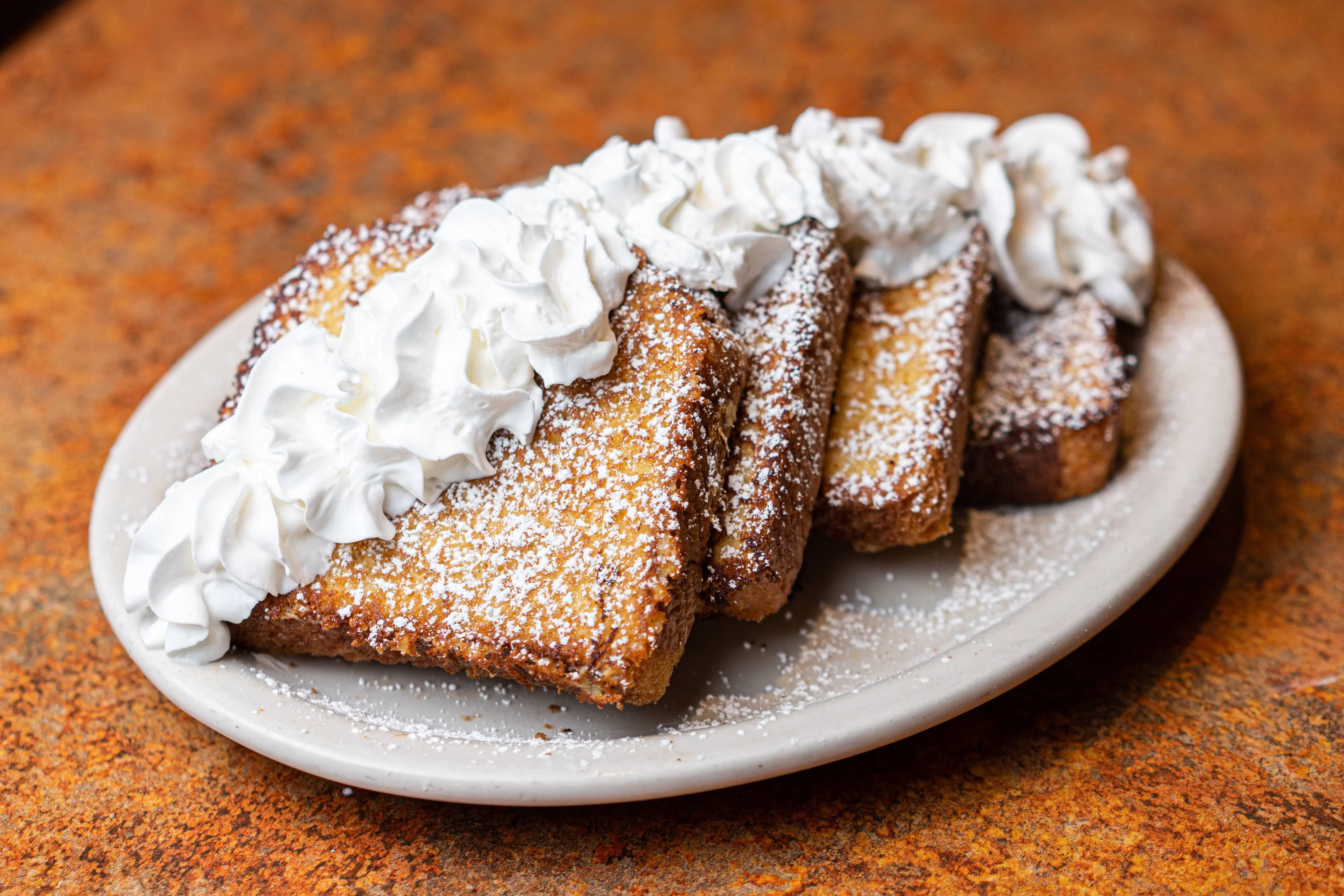 French toast topped with whipped cream and powdered sugar
