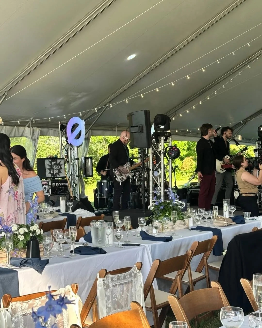 Live band performing at a wedding reception under a tent
