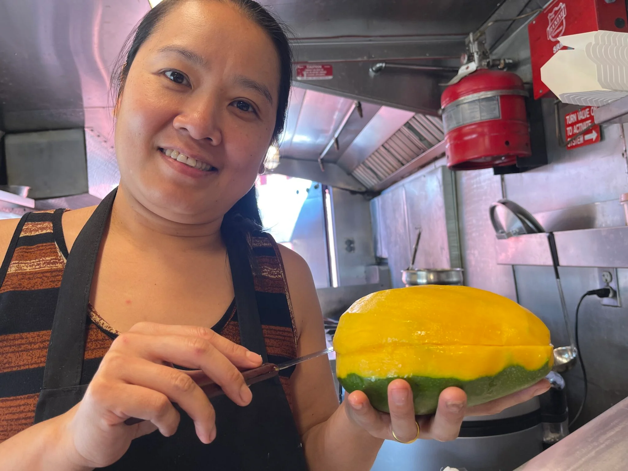 Chef preparing a fresh papaya in a food truck kitchen