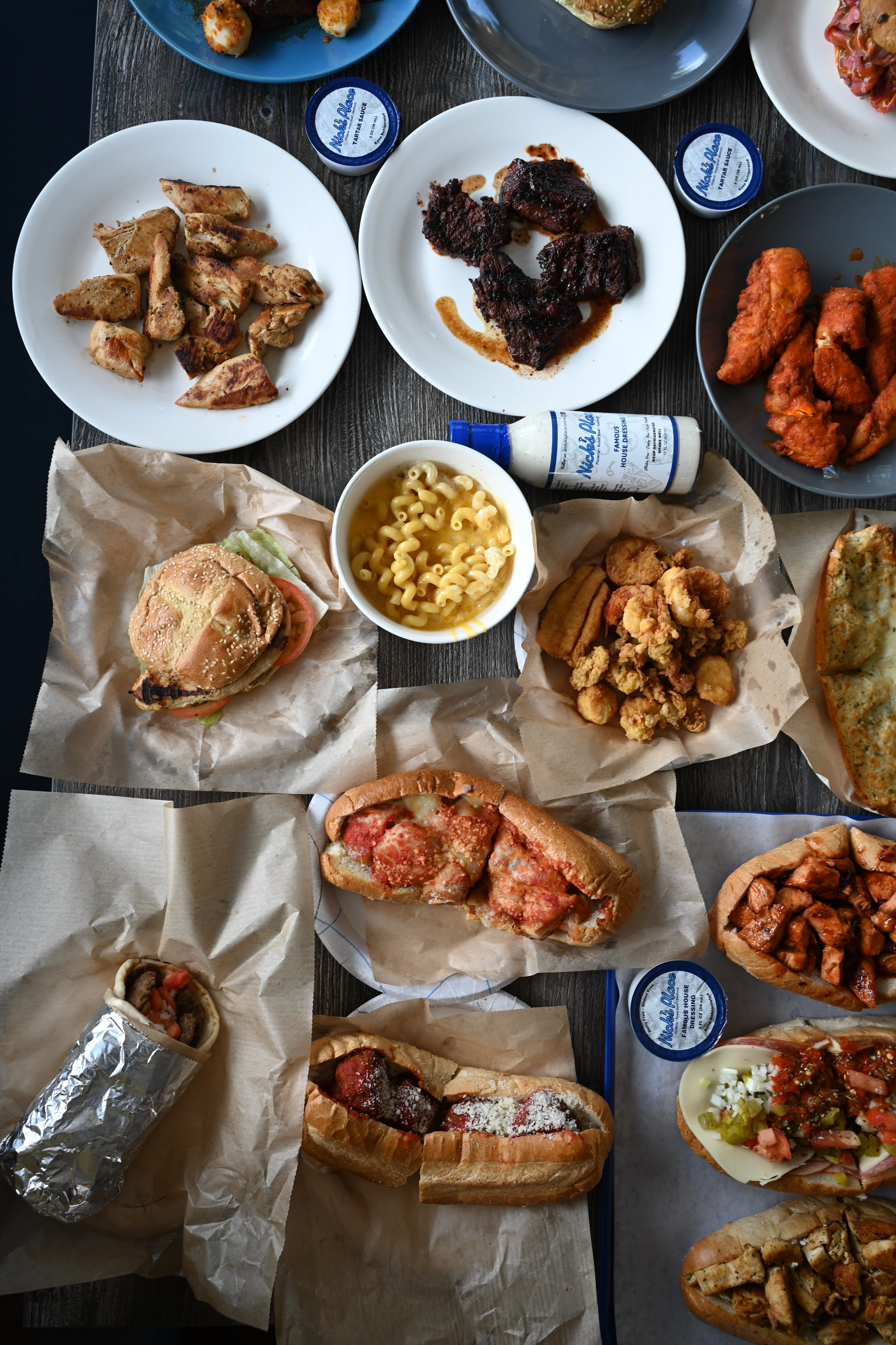 Assorted American comfort food platter with sandwiches and fried chicken