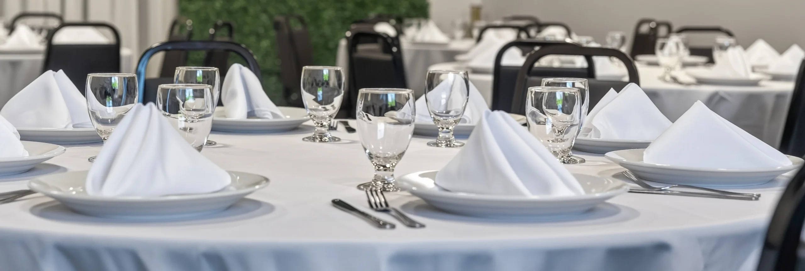 Elegant restaurant dining setup with white tablecloths and glassware