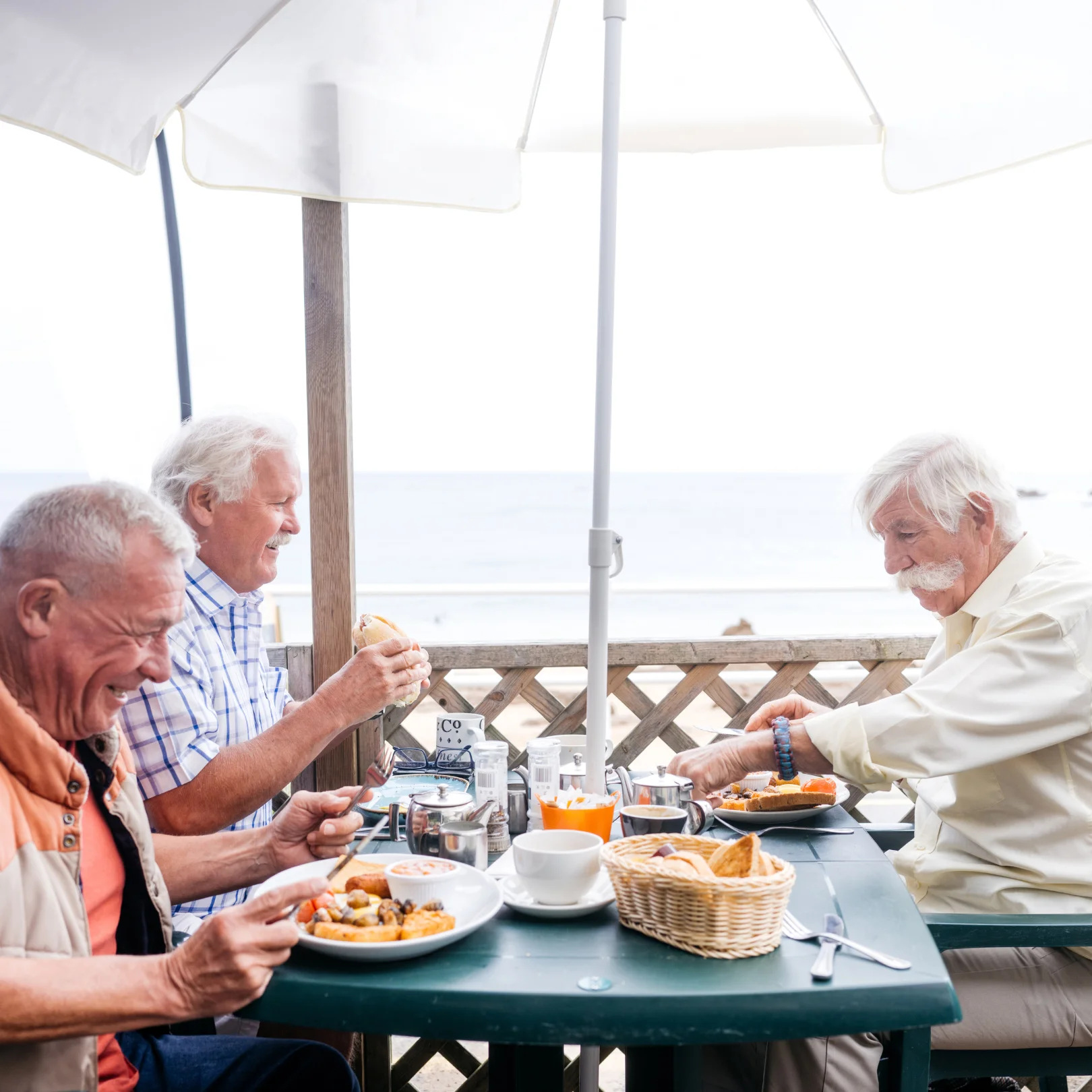 Friends enjoying breakfast by the beach with a view