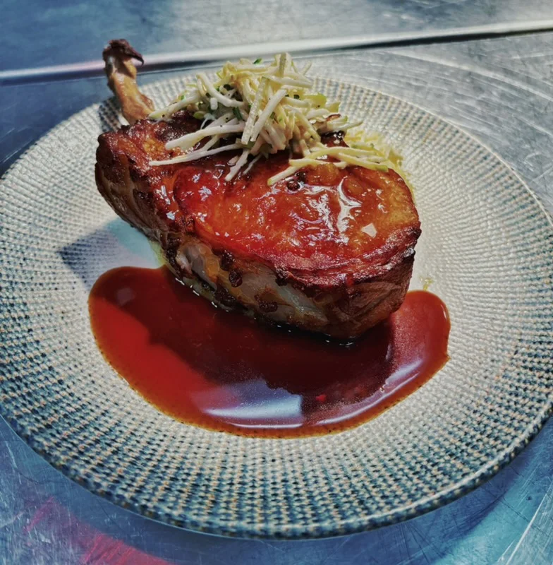 Crispy pork chop with tangy sauce and ginger garnish