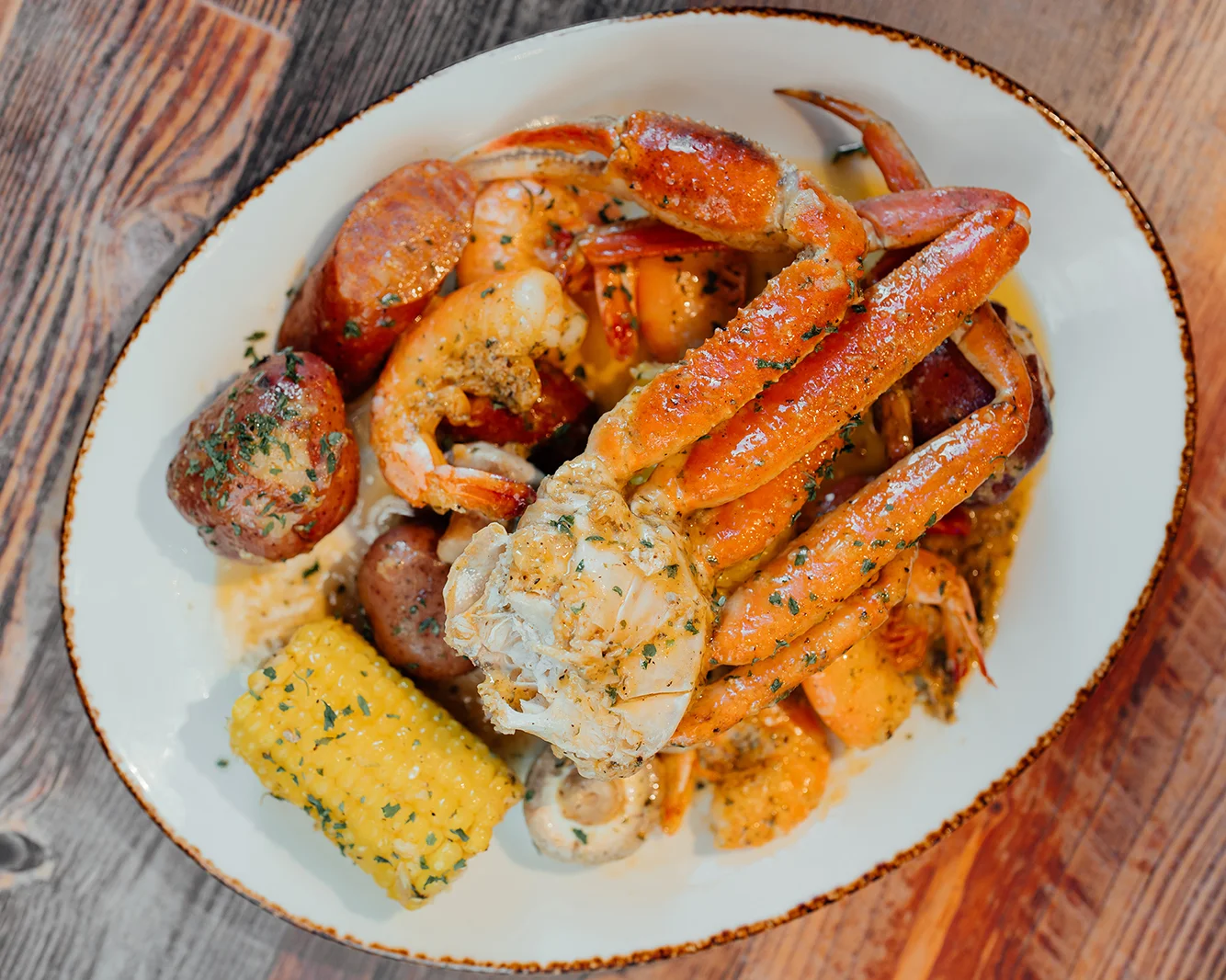Seafood boil with crab, shrimp, and corn on a rustic plate