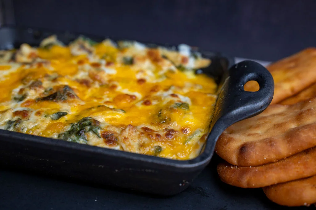 Cheesy spinach and artichoke dip served with naan bread