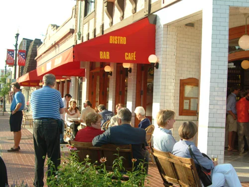 Outdoor dining scene at a bistro with patrons enjoying the ambiance