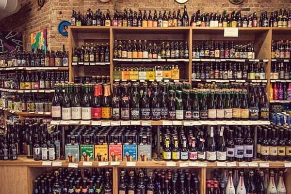 Variety of craft beers displayed on wooden shelves