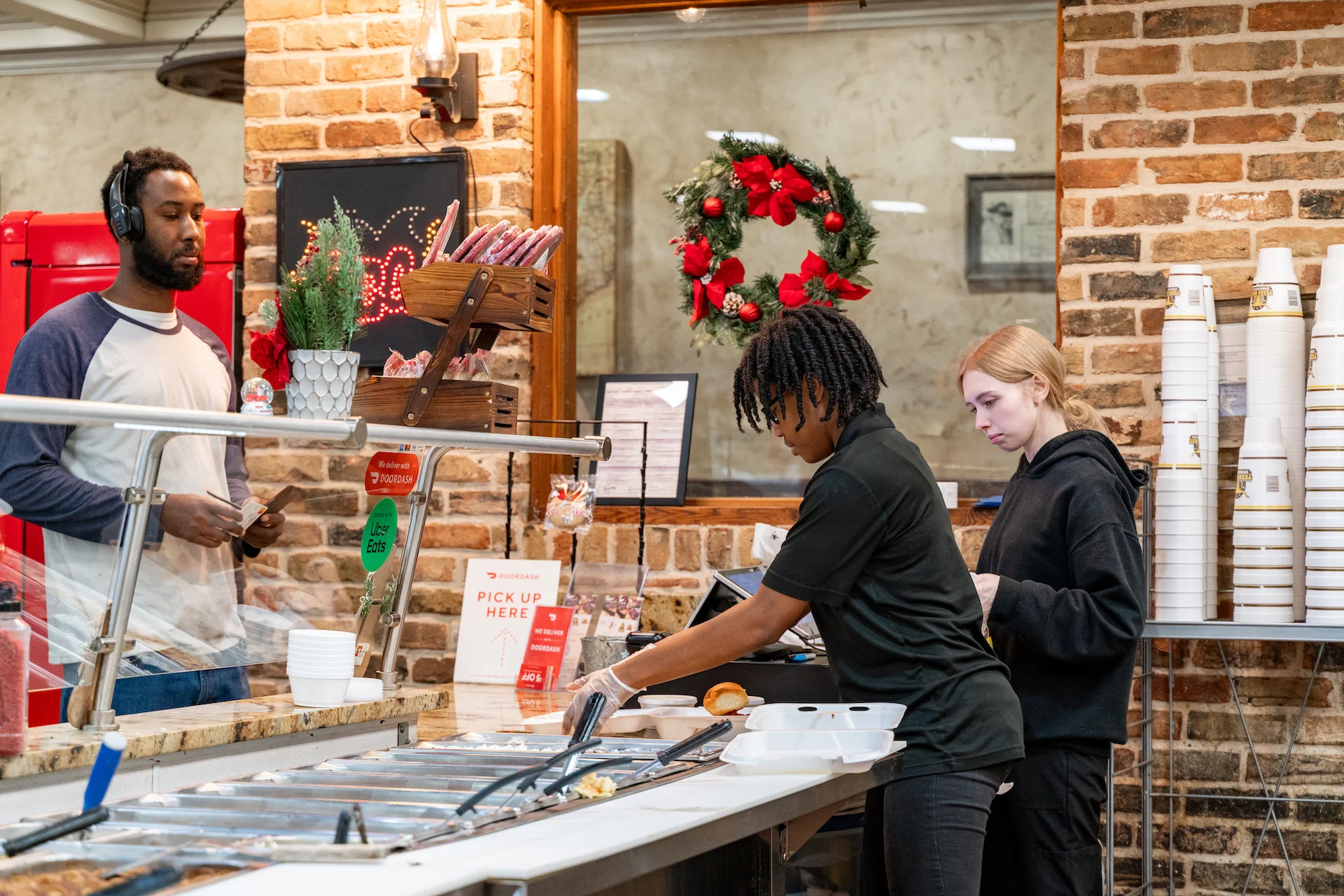 Restaurant staff serving food at a bustling counter