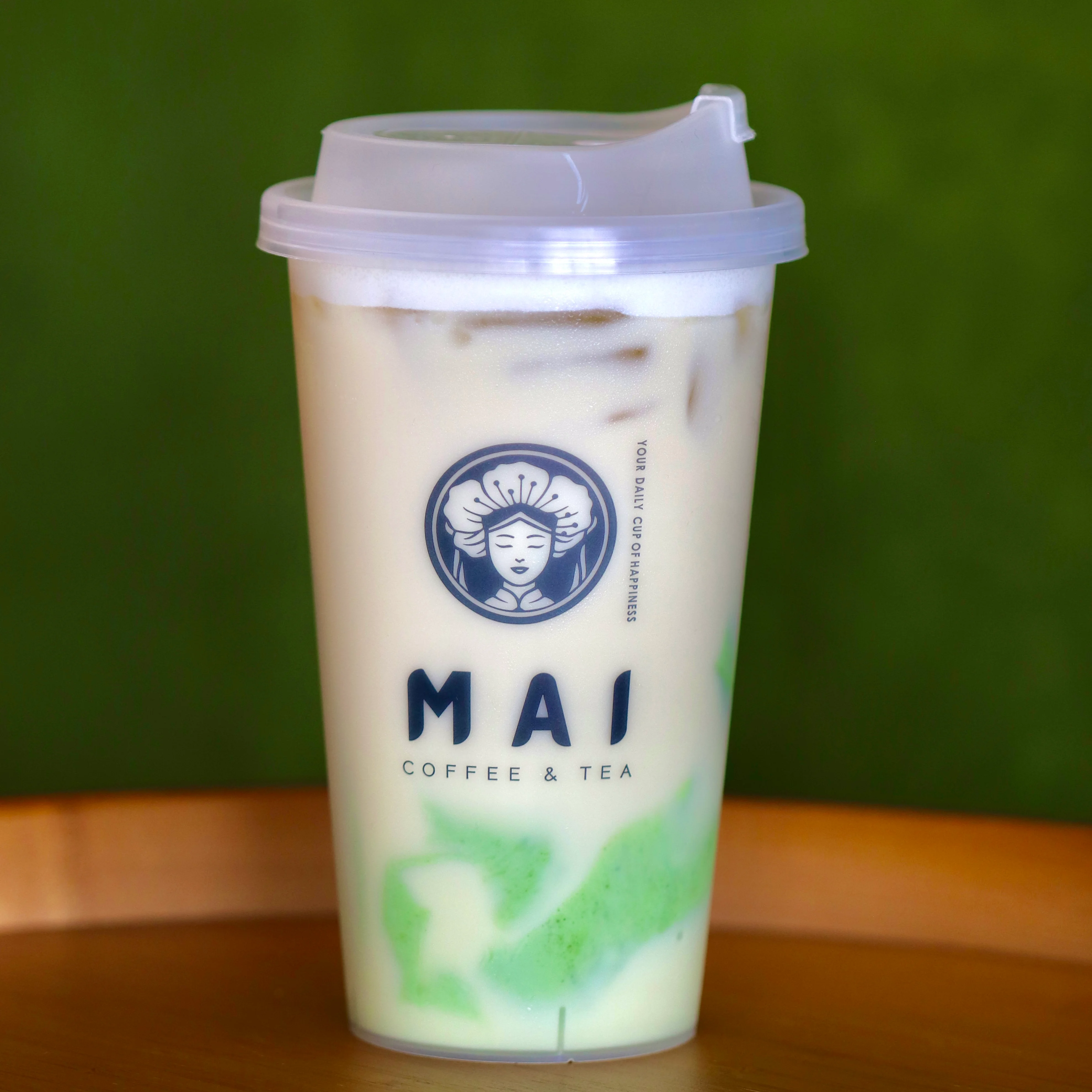 Iced matcha latte in a clear cup from MAI Coffee & Tea