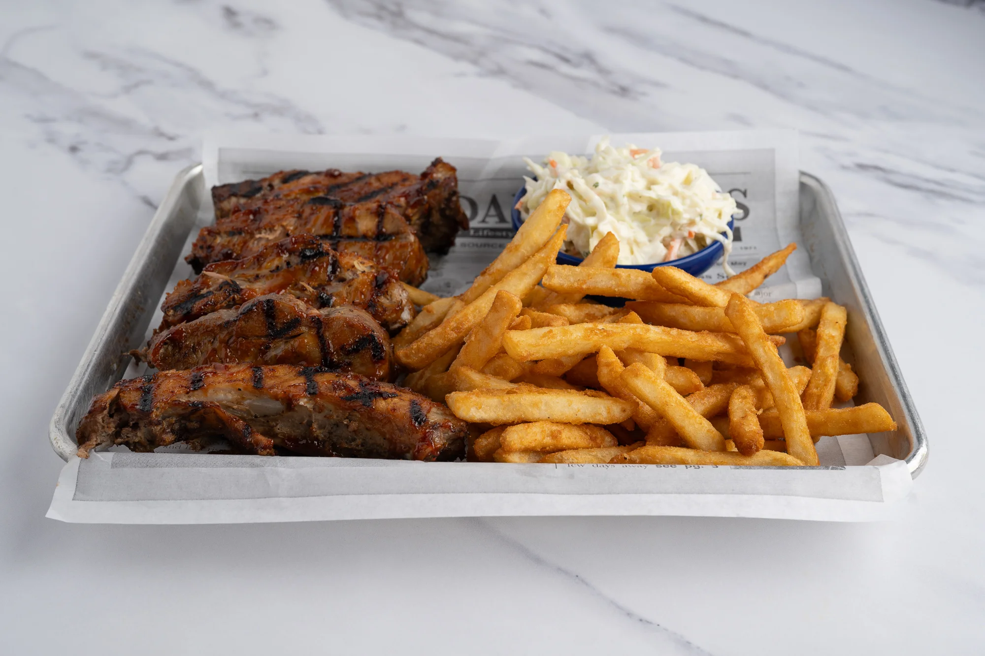 Grilled barbecue ribs with fries and coleslaw