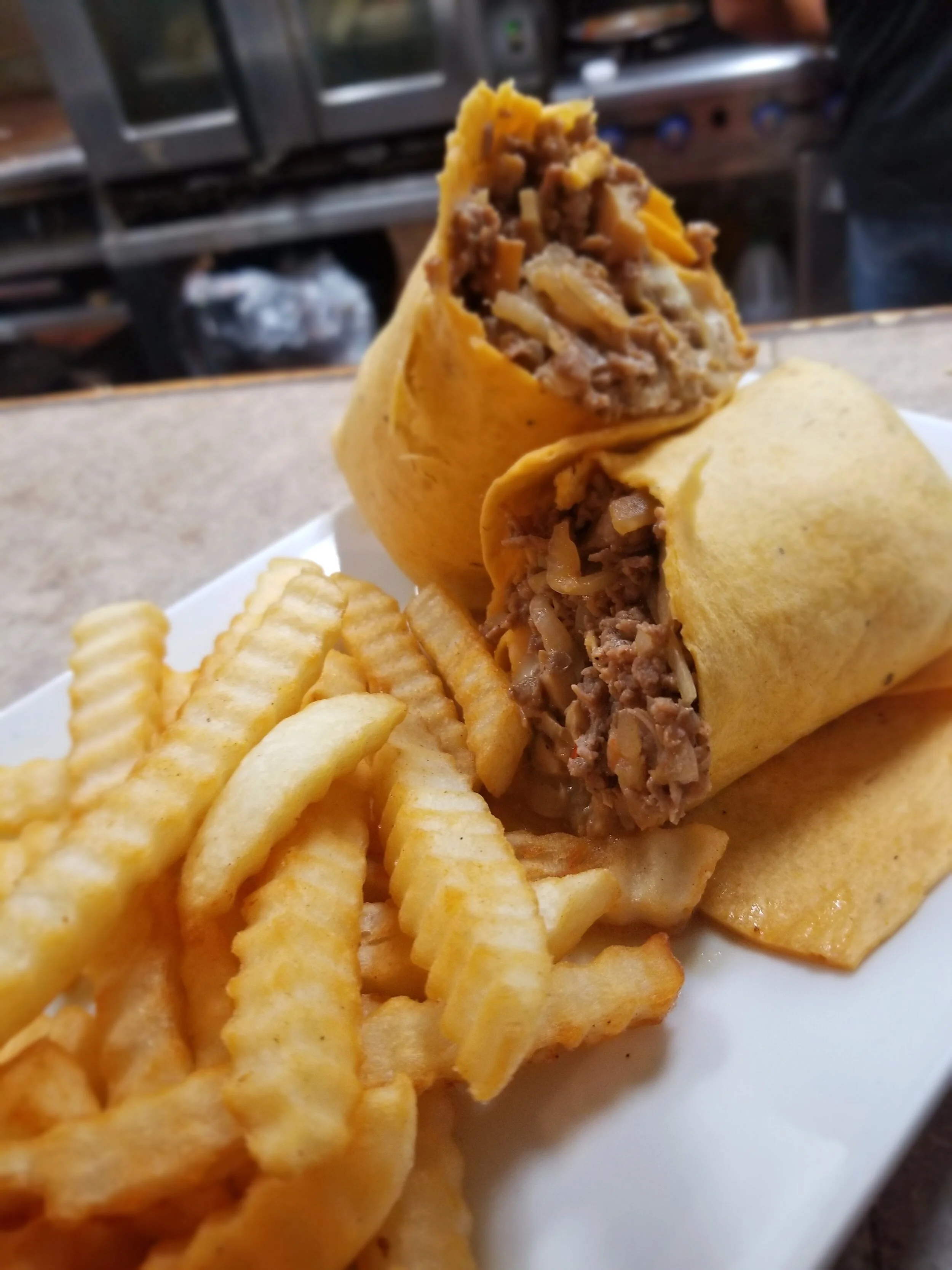 Delicious burrito with beef and fries on a plate