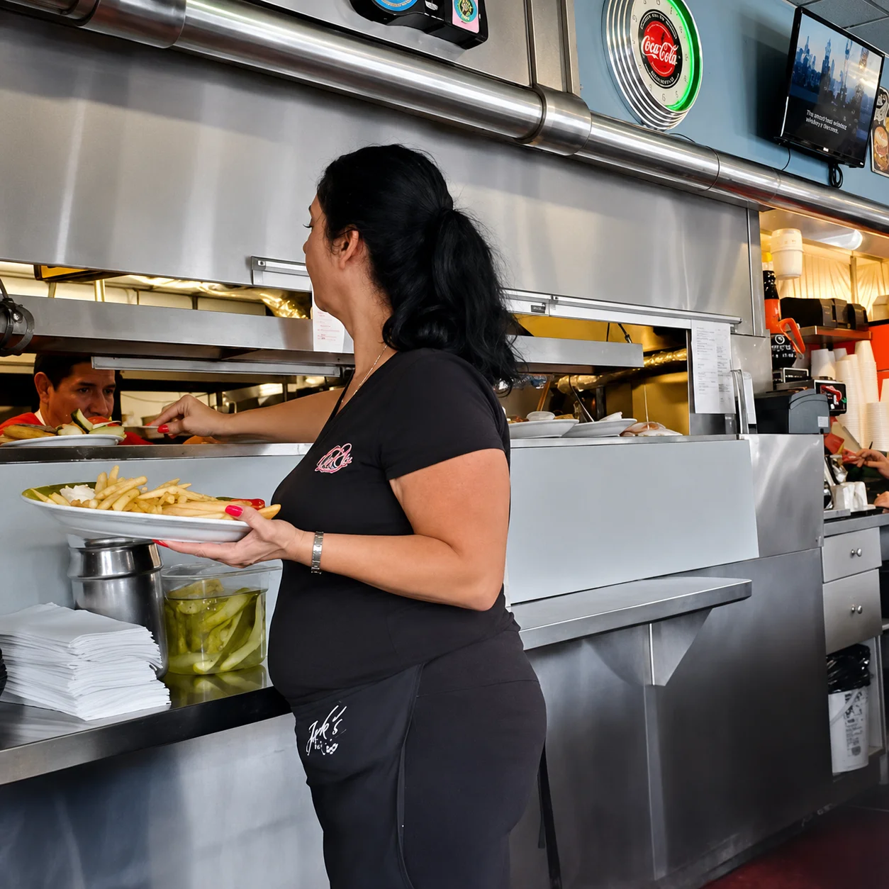 Restaurant team member serving freshly prepared meals from the kitchen at Jack's Hollywood Diner.