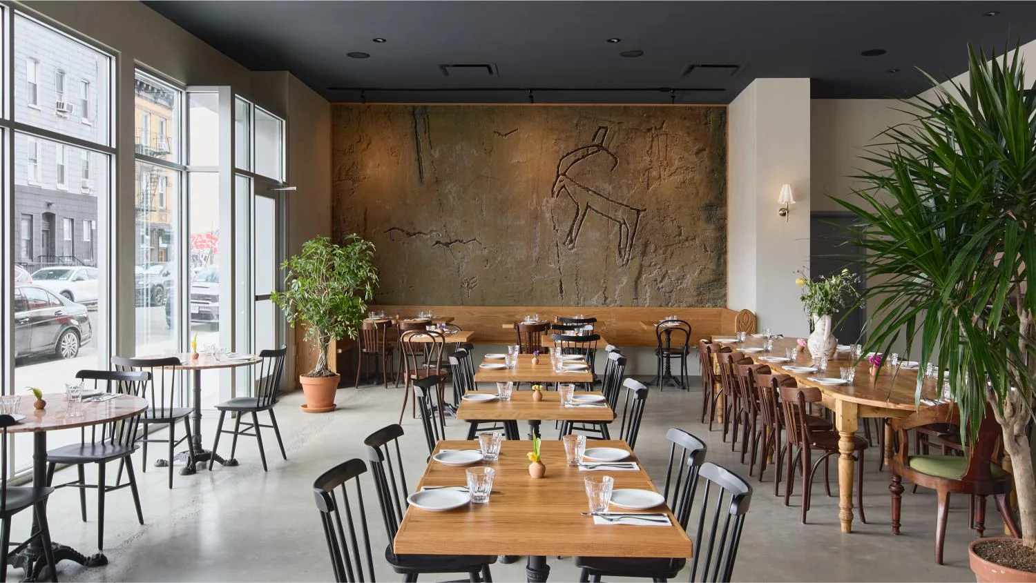 Modern restaurant interior with wooden tables and plants