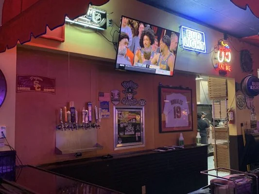 Cozy bar interior with neon lights and sports on TV