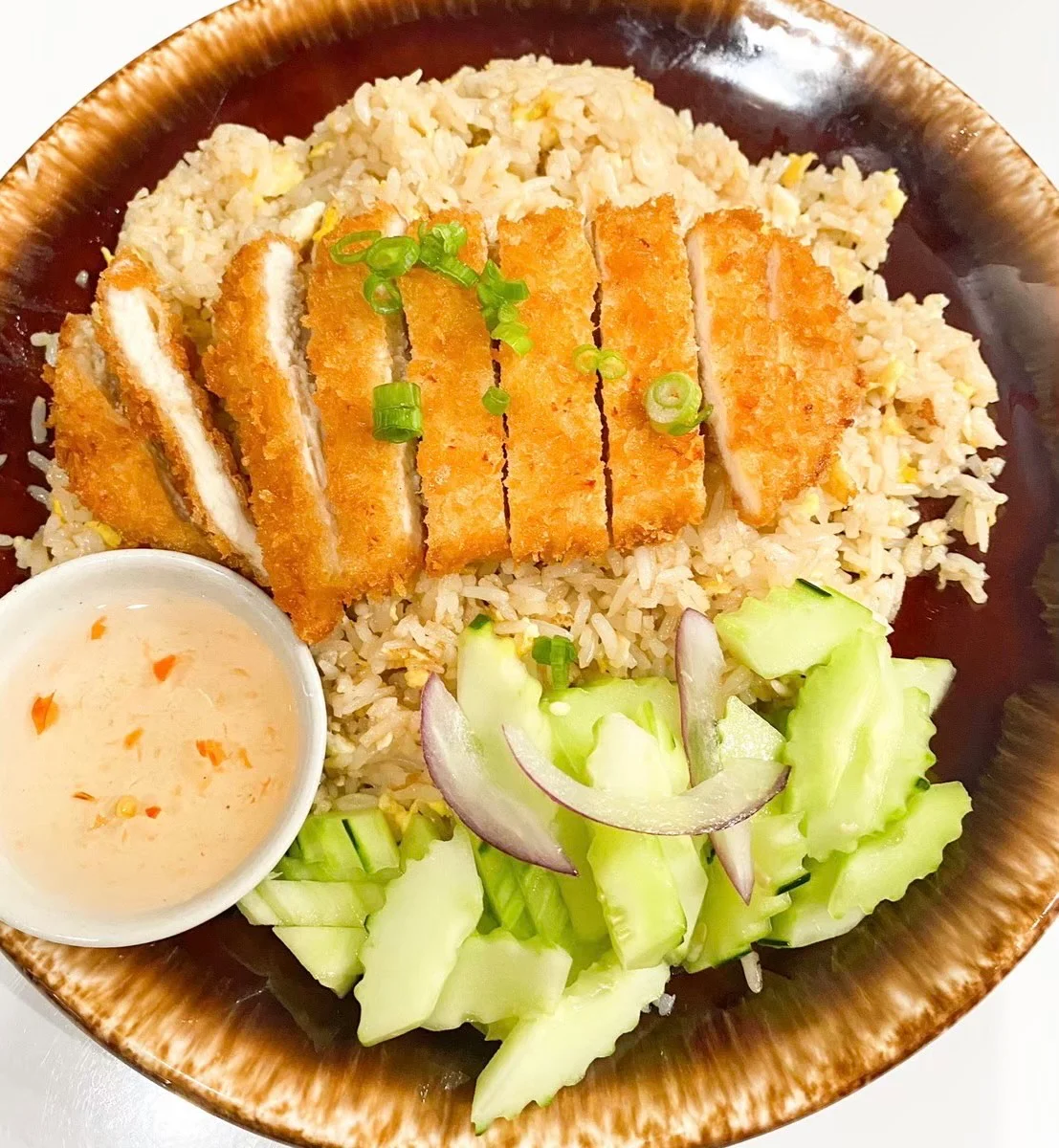 Crispy chicken katsu served with fried rice and cucumber salad