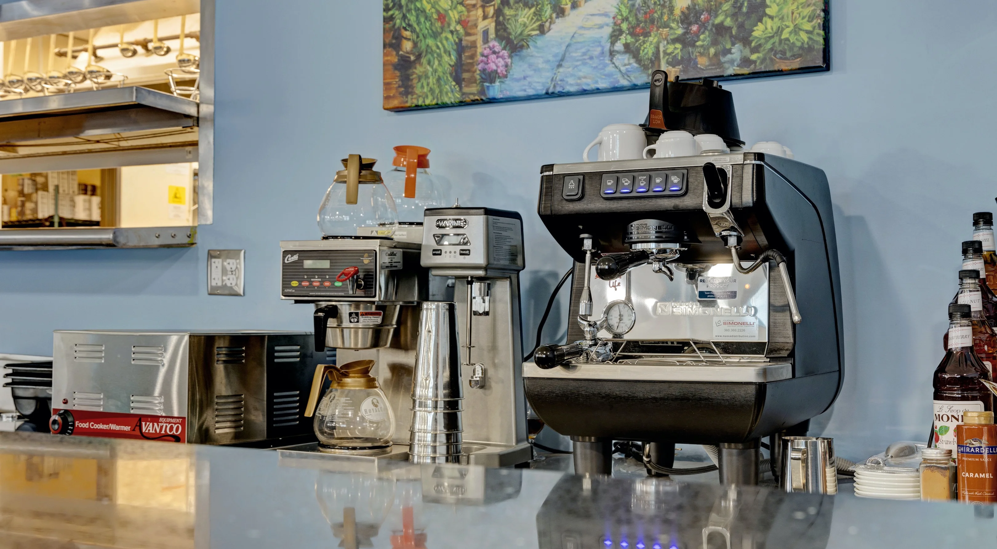 Coffee equipment and supplies in a restaurant kitchen setting.